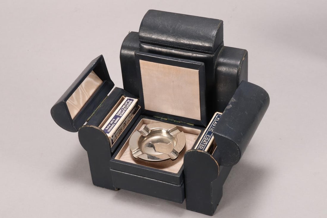 20th Century Novelty Games Compendium,: in the form of an Art Deco leather 'Bridge' chair, with cards, ashtrays and scoring pads, in the arms, seat and chair back, 20cm x 20cm x 16cm Published: Antique Boxes: Inside and Out, colour plate 46