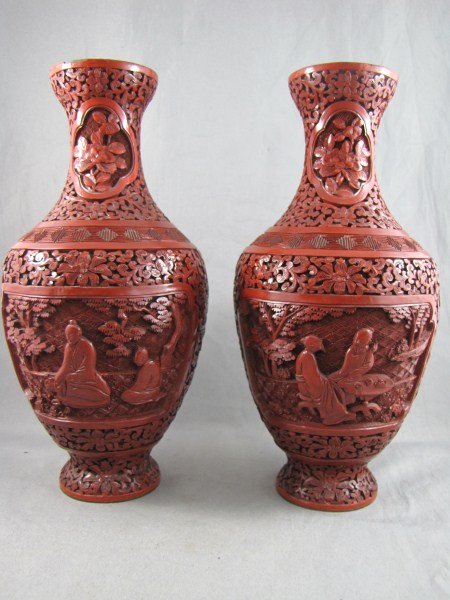 Pair of Chinese Cinnabar Vases,: of tapering form, decorated with figures seated in gardens, on a ground of flowers, h 22cm