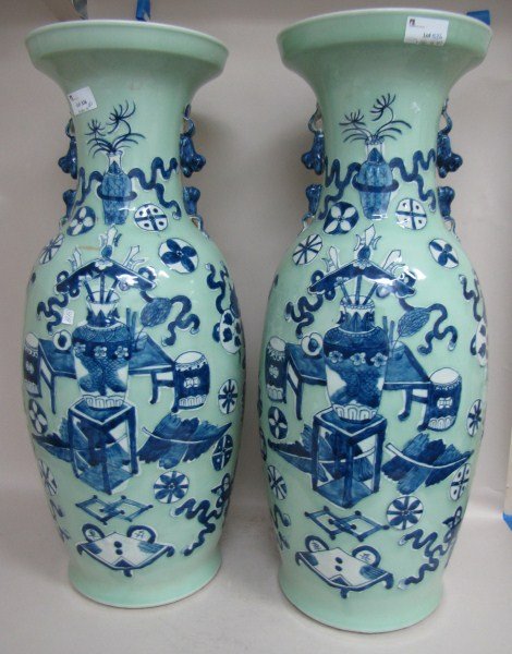 Pair of Large Chinese Porcelain Blue and White: Vases, of ovoid form, beautifully decorated with a central image of a vase with weapons, resting on a table surrounded by precious objects, in tones of blue and white on a soft pale blue ground, h 60c