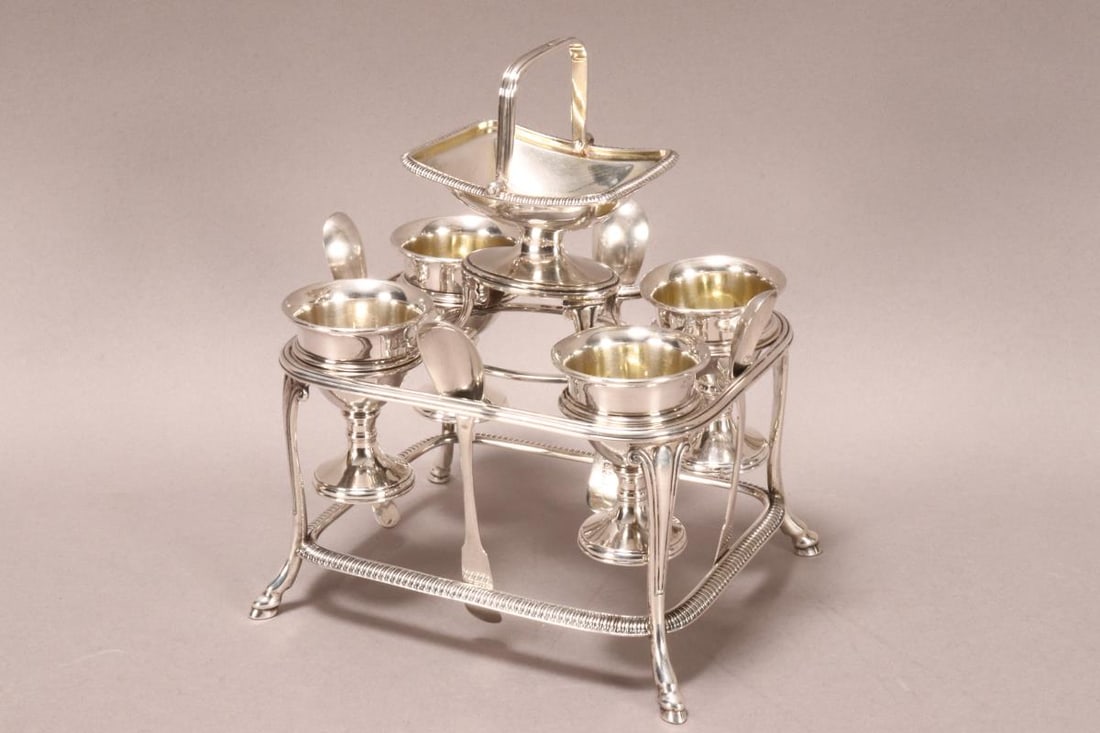 George III Sterling Silver Egg Cruet,: hallmarked London, 1808, SW (Samuel Whitford II or Samuel Wheatley), with central pedestal salt with swing handle, set above rectangular frame with gadrooned border, set with four tapered egg cups wit