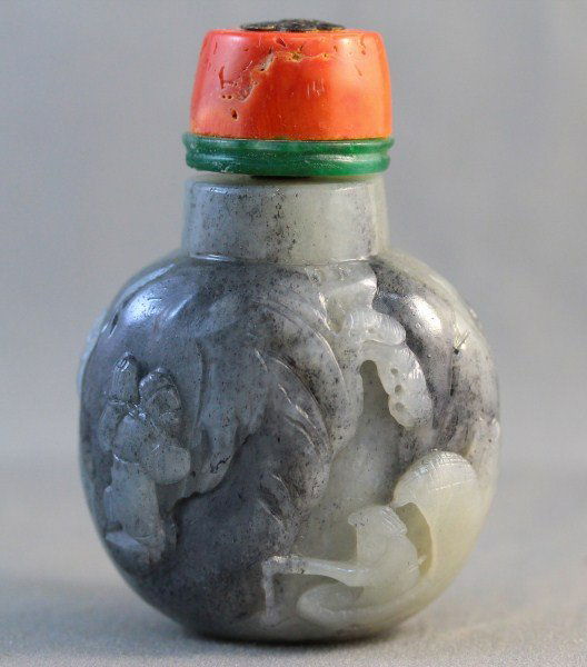 Chinese Black and White Jade Snuff Bottle and: Stopper, of baluster form, carved with figures, with coral stopper, h 8cm