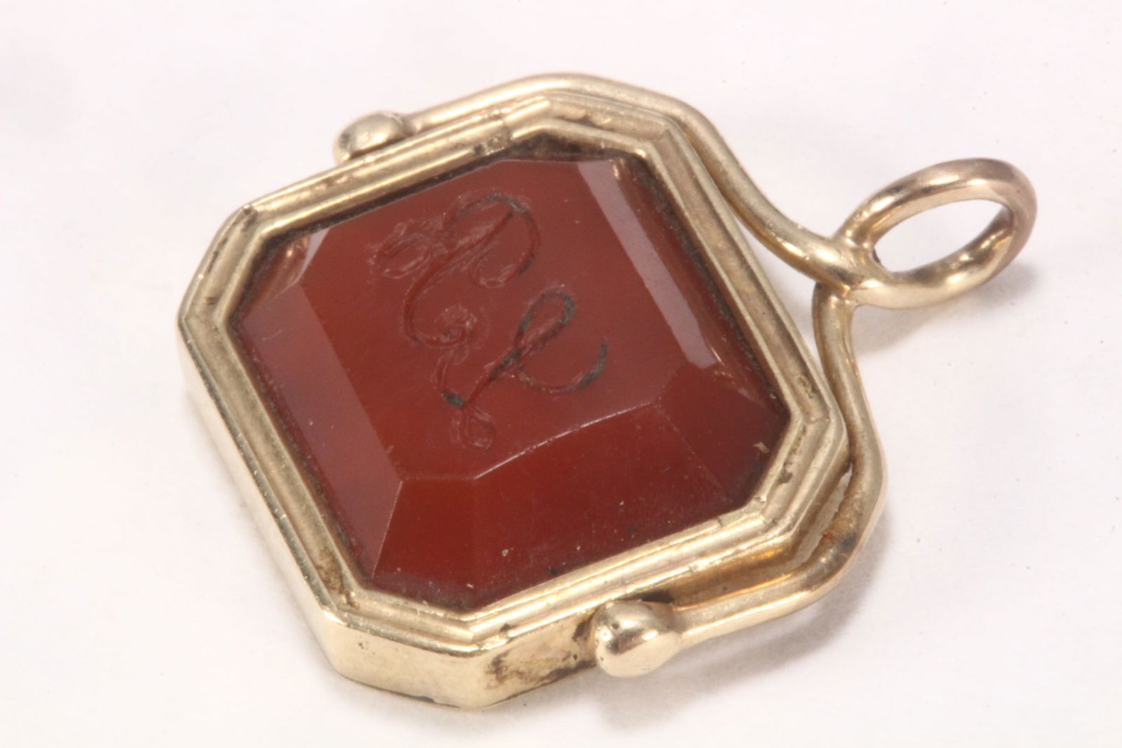 14ct Yellow Gold and Carnelian Swivel Fob Seal,: unmarked (tested as 14ct), of rectangular form, decorated with pierced panel of flowers and foliage, set with carnelian seal with engraved initials to verso, length 2cm Published: Chatelaines: Utility