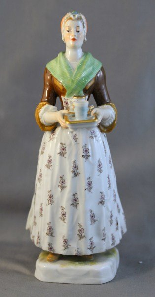 Meissen Porcelain Figure,: depicting a women holding a tray with coffee cup and saucer in tones of green and brown, underglaze blue crossed swords mark and inscribed T 501, h 19cm