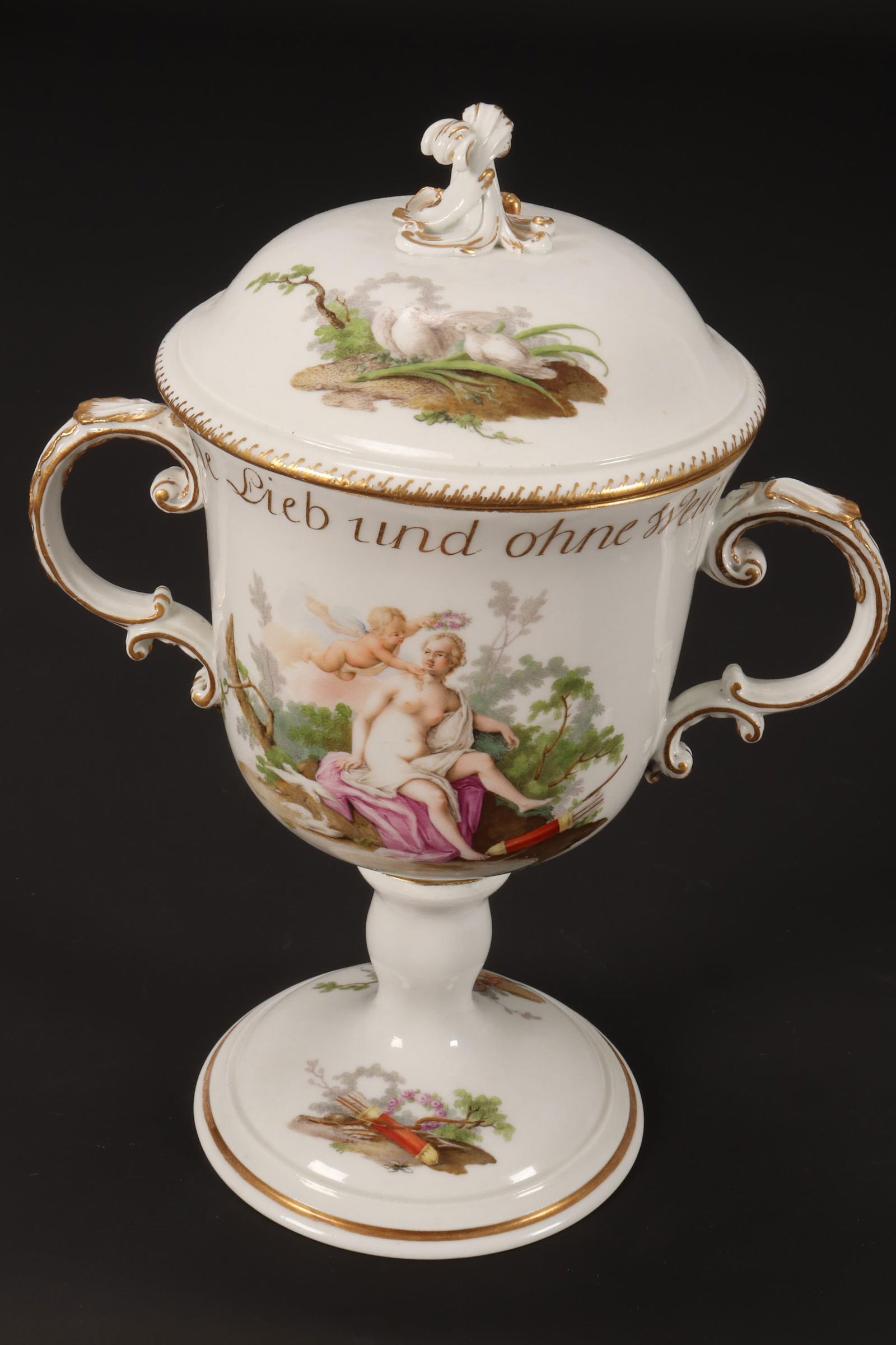Large 19th Century Meissen Porcelain Twin Handled: Urn and Cover, set with scrolled finial and handles, the body painted with Venus and Cupid to one side, with Bacchus and leopard skin verso, inscribed 'Ohne Lieb und ohne Wein, was ist unser Leben?' w