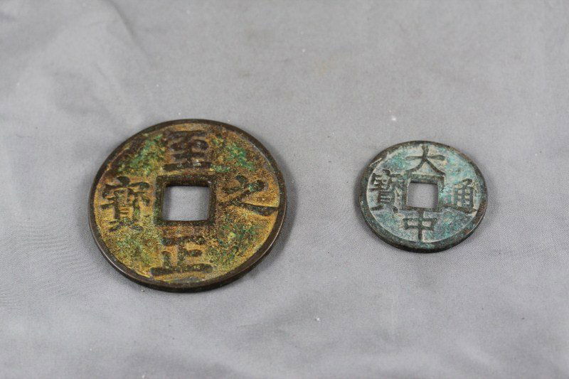Two Chinese Bronze Coins,: both of circular form, with pierced squares to centre, and surrounded by character marks, (2)