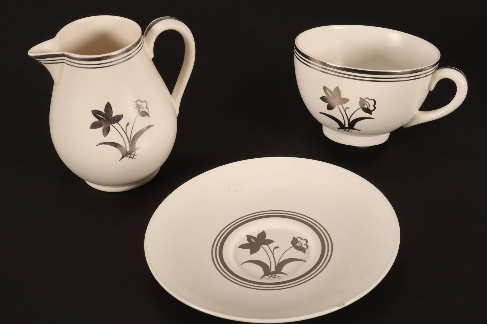 Wedgwood Keith Murray Moonstone Lotus Flower Platinum Cup, Saucer and Milk Jug,: c.1938, decorated with spray of flowers, with banded borders (3)