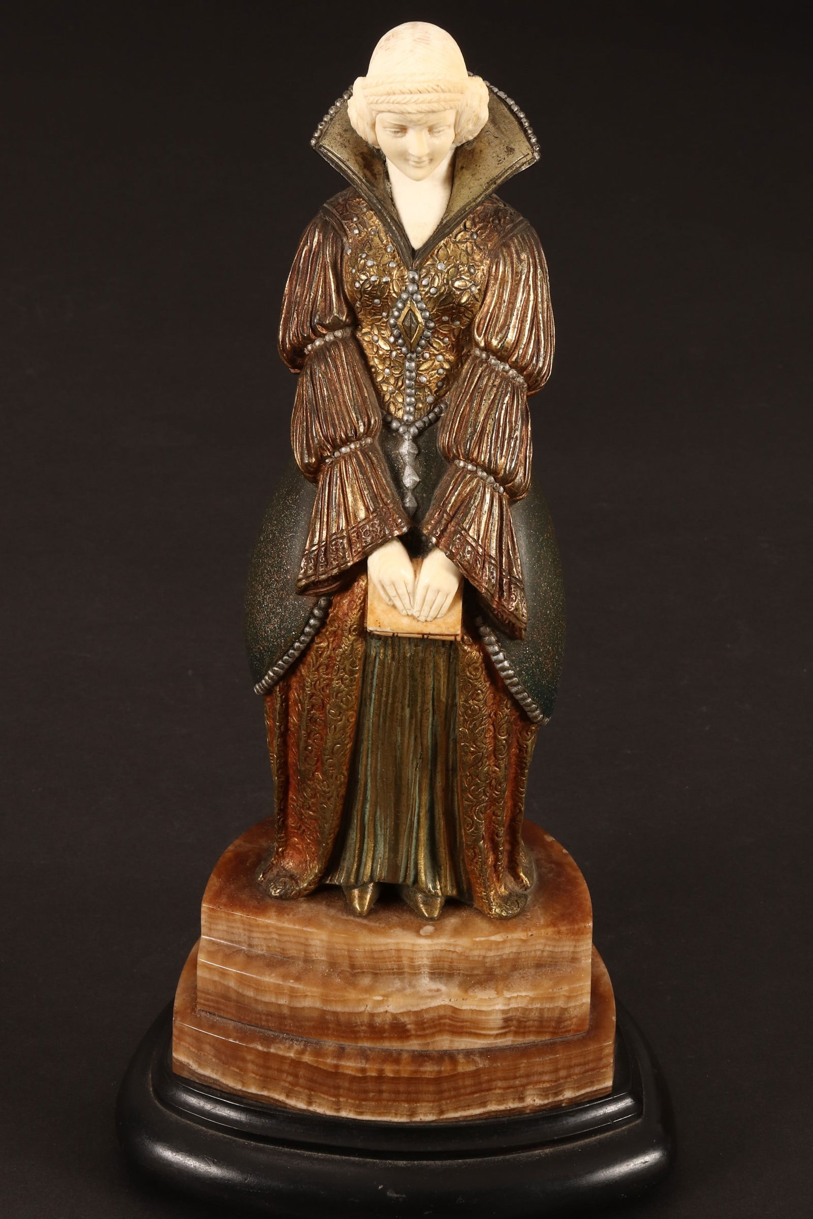 Demetre H. Chiparus (Romanian, 1886-1947),: After Reading, c.1925 cold painted, on onxy base (on later wood base) signed Chiparus to base total height 25cm (excluding wood base) Catalogue Note: Chiparus, Alberto Shayo, page 92, plate 24. Shippi