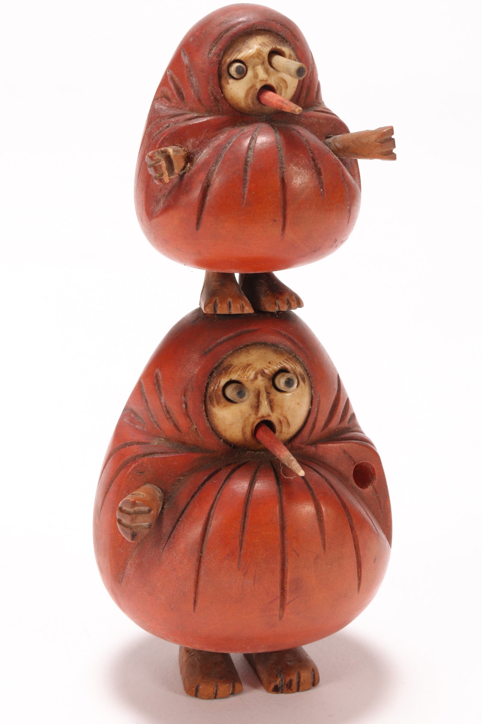 Japanese Meiji Period Kobe Daruma Toy,: with one small figure standing on the head of a larger figure, with protruding eyes and tongues, with bone faces and orange coloured cloaks, a/f (missing one hand, missing implements), height 10cm, Pr