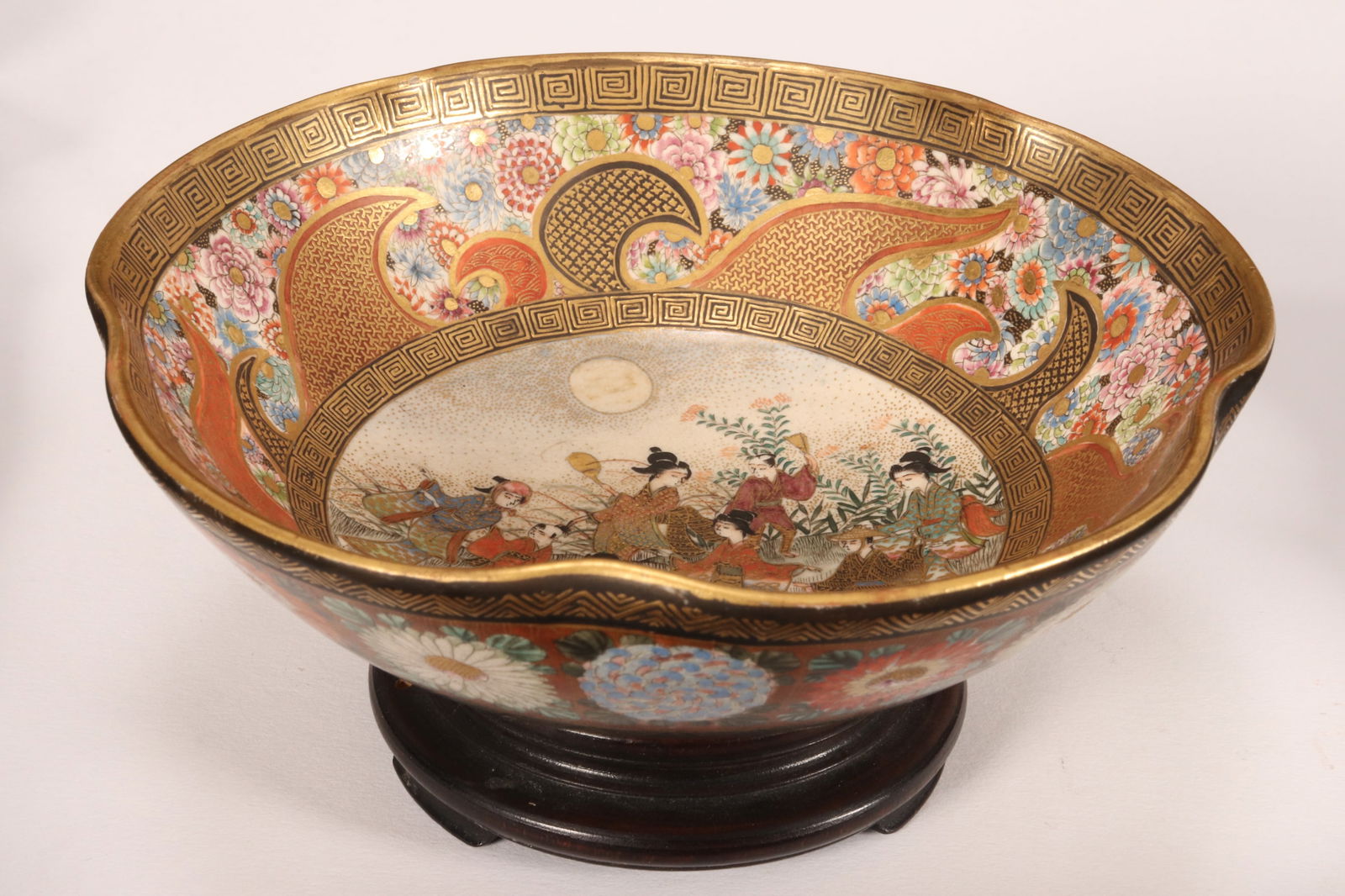 Satsuma Meiji Period Pottery Bowl,: of circular form with a pinched rim, the interior decorated with central roundel depicting figures in a garden setting under moonlight, surrounded by a thousand flowers, key fret and wave borders, the
