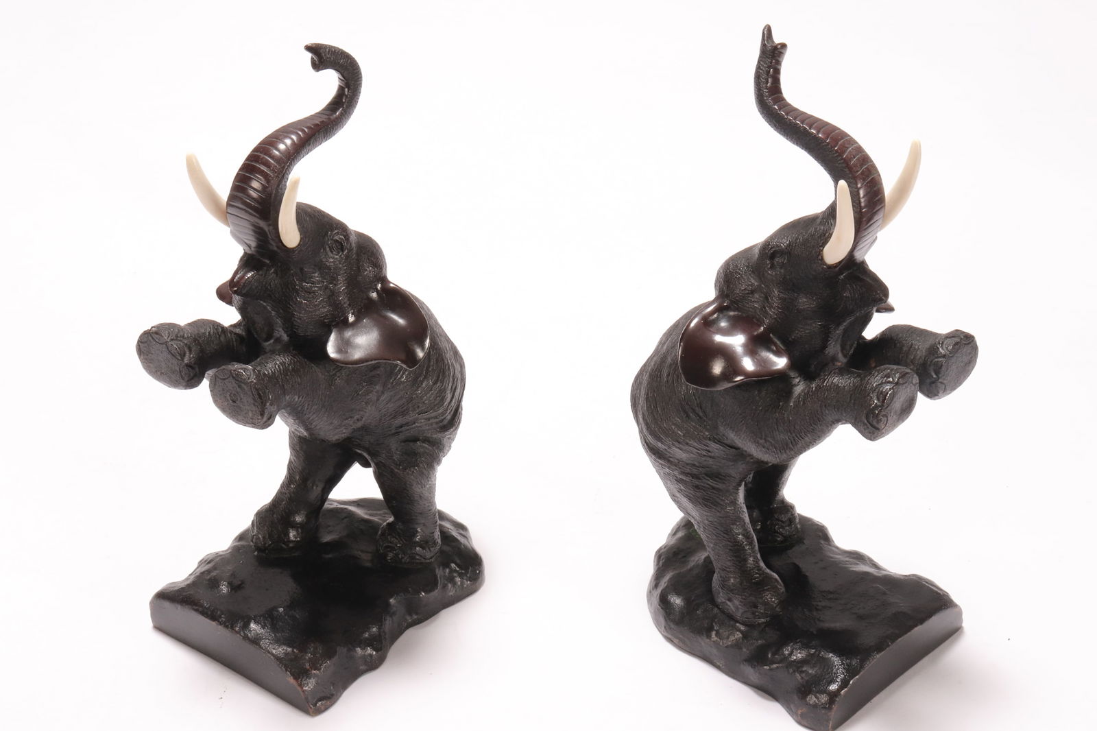 Pair of Japanese Bronze Figural Bookends,: c.1920's, in the form of elephants standing on their hind legs, with trunks raised and set with tusks, incised mark to base, height 22cm (2)