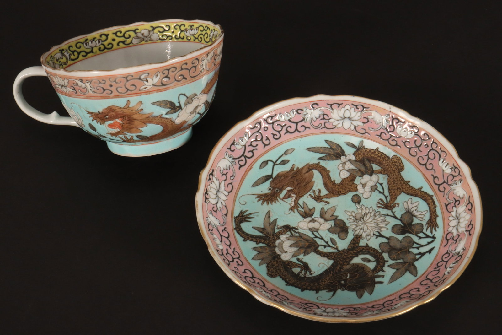 Chinese Porcelain Cup and Saucer,: decorated with dragons, chrysanthemum and peonies, surrounded by lotus scroll border, in tones of pink, blue and white, with gilt accents, red seal mark to base, height of teacup 5.5cm, diameter of sa