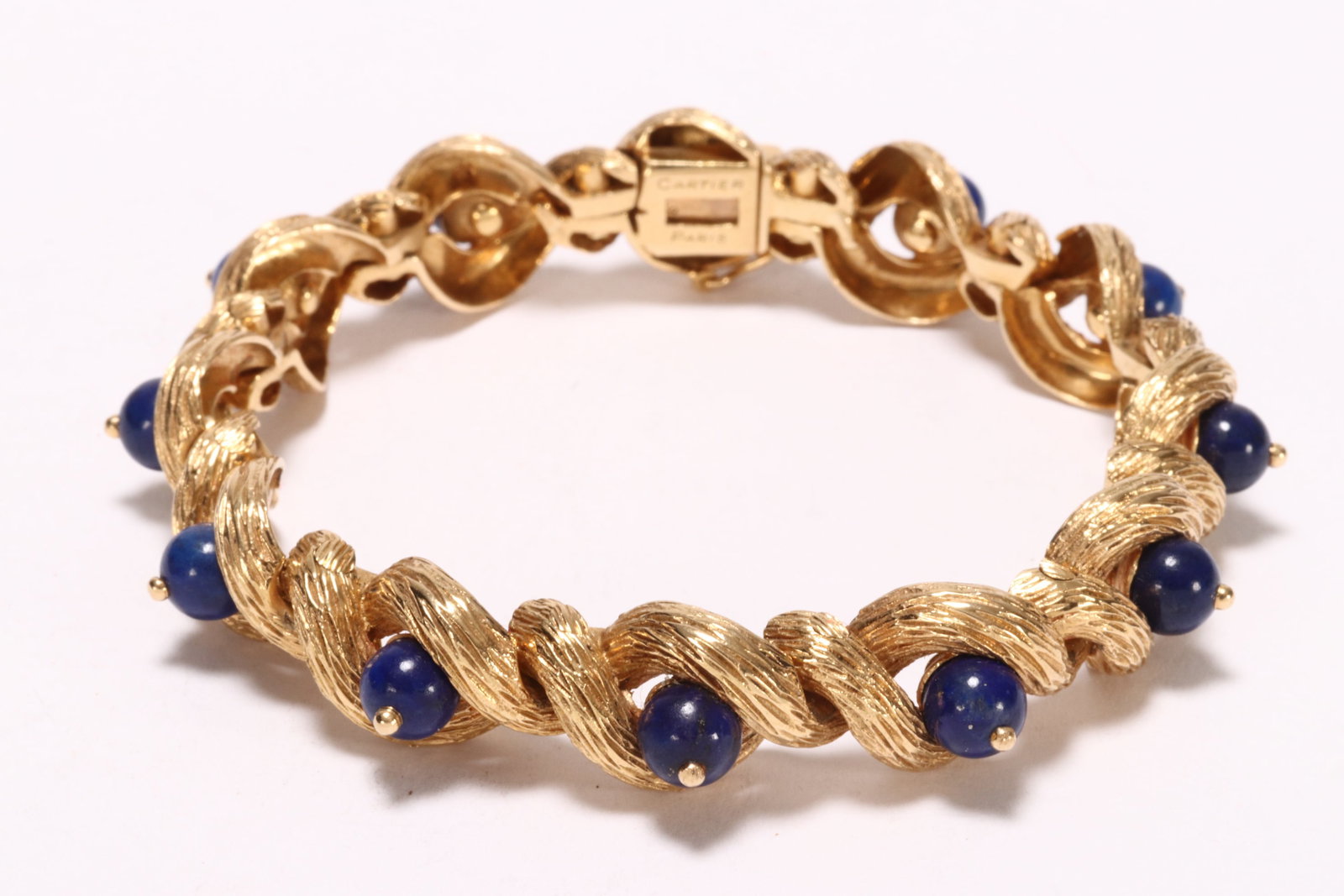 Cartier 18ct Gold & Lapis Lazuli Bracelet,: c.1950's, signed Cartier, Paris, with French eagle head 18ct gold fineness stamps to clasp, the bracelet comprising twelve 18ct yellow gold links in interwoven rope/branch design with textured finish,