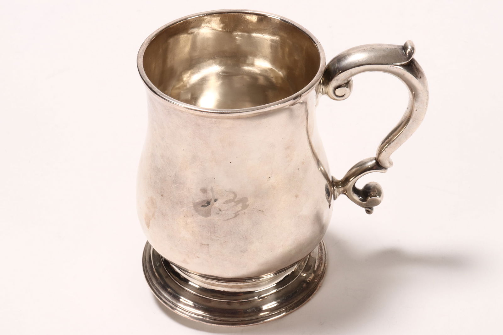 George II Sterling Silver Mug,: hallmarked London, 1738, WK (probably William Kidney), of baluster form, with scrolled handle, raised on a stepped circular foot, total weight 246g, height 10cm