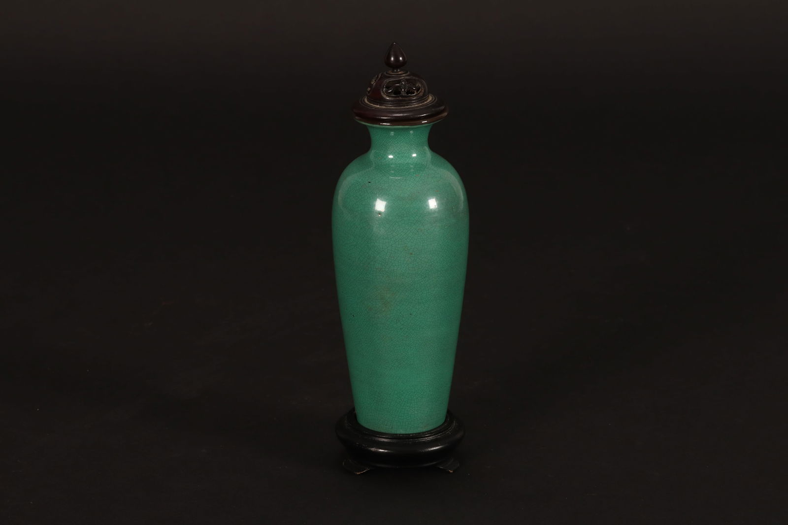 Chinese Green Crackle Glaze Vase, Cover and Stand,: of slight tapering elongated cylindrical form, with short neck and everted rim, with pierced wooden cover, and circular wooden stand, height 15cm and 20cm (including cover and stand)