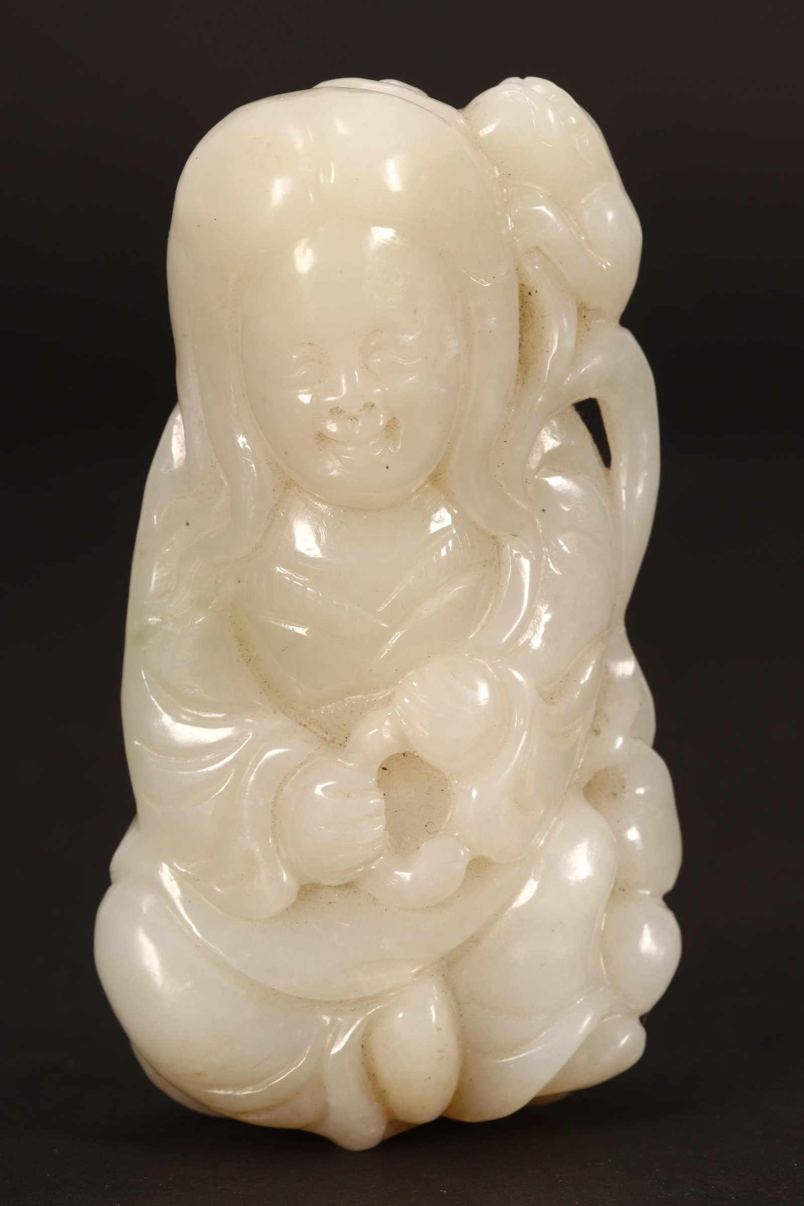 Chinese White Jade Carving,: depicting a seated woman, with pleasant expression and toad perching on her shoulder, with three coins to the reverse, height 10.5cm