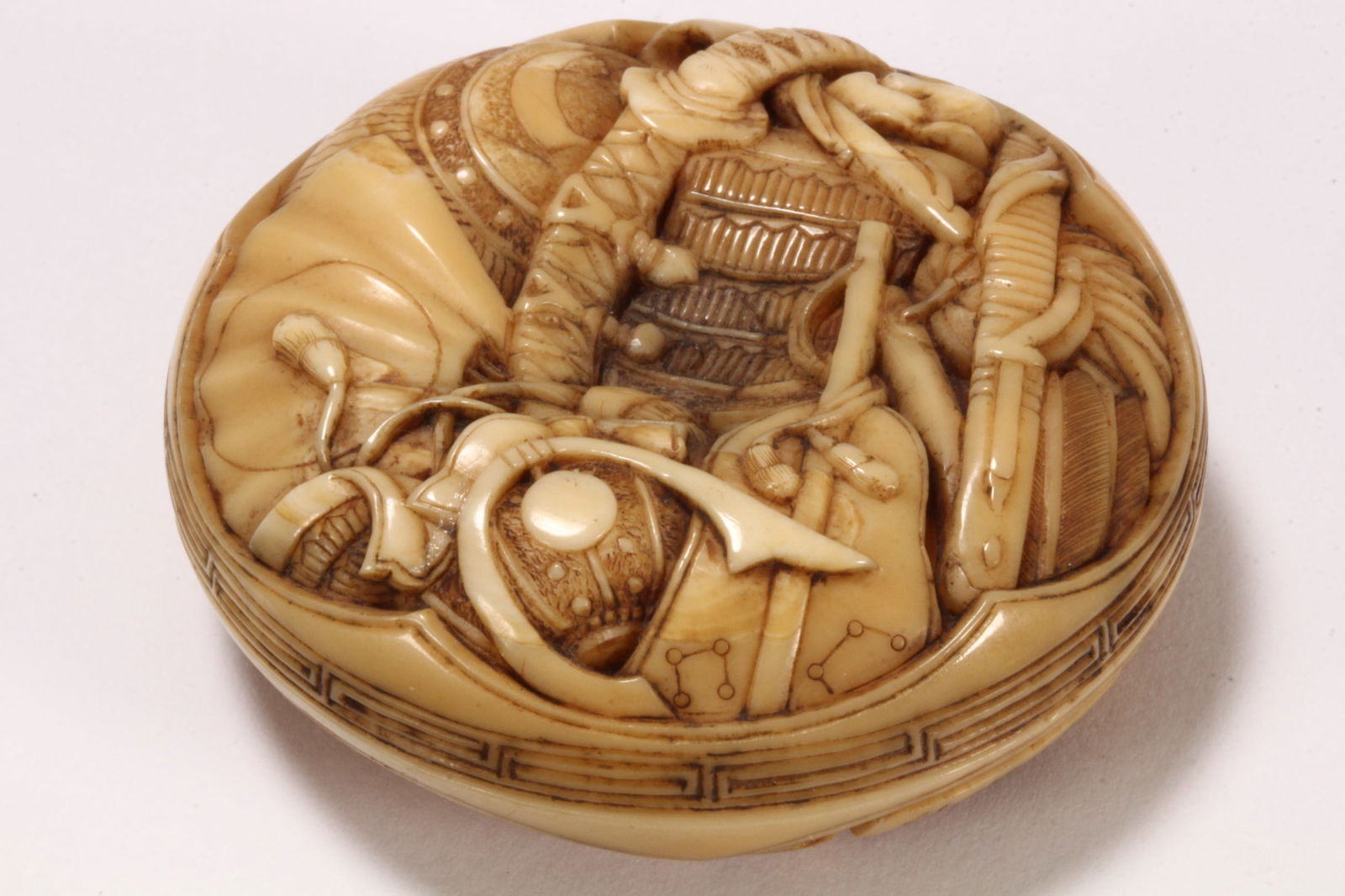 Good Edo Period Japanese Manju Netsuke,: the cover finely carved in relief with emblems of the Shinokosho four class system, with symbolic representations of samurai, peasantry, artisans and merchants, the underside carved with jinkai, bonsh