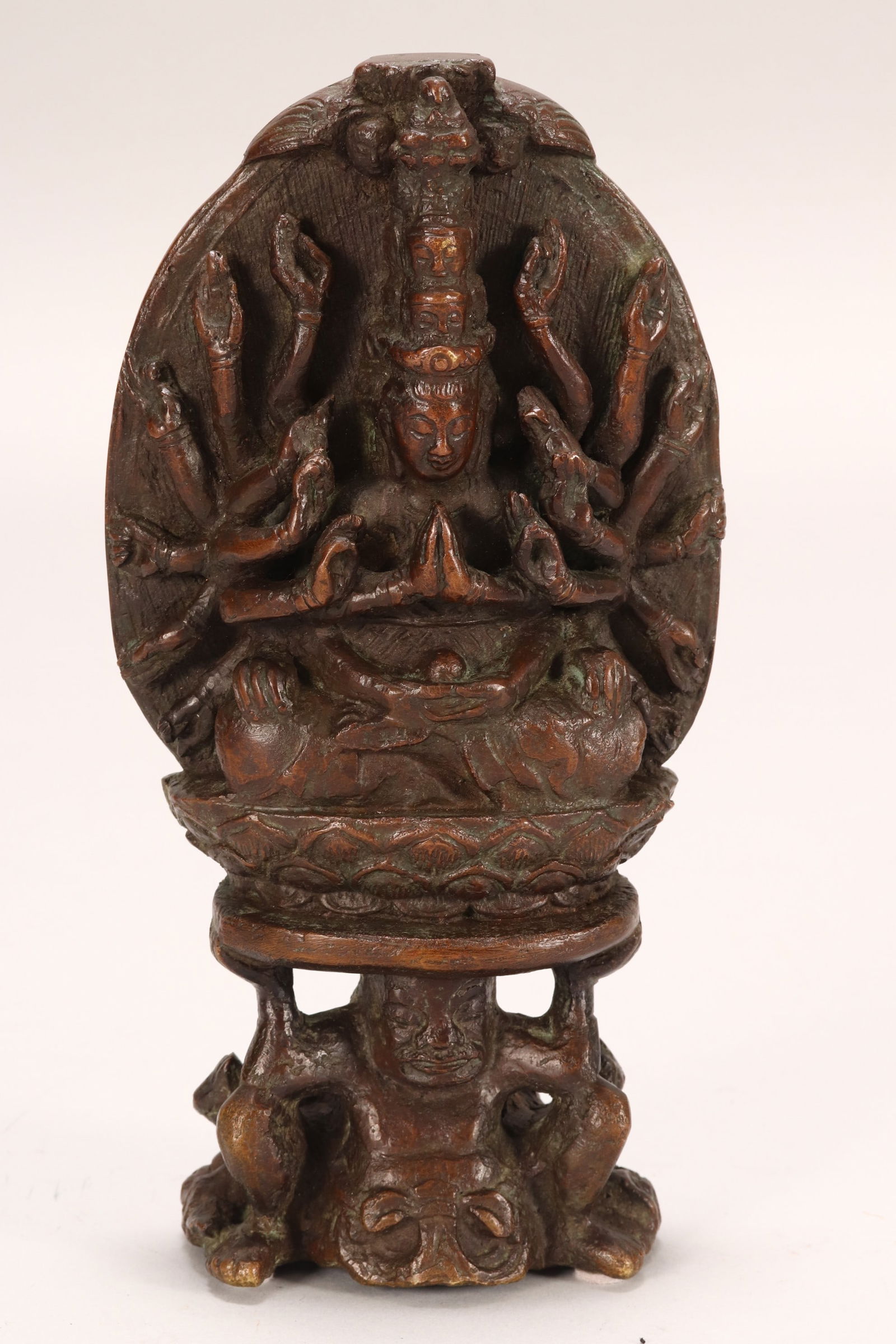 18th Century South Indian Bronze Avalokitesvara,: depicted seated with multiple arms, raised upon attendant, decorated with dragon and cloud scrolls verso, heavy, height 22cm