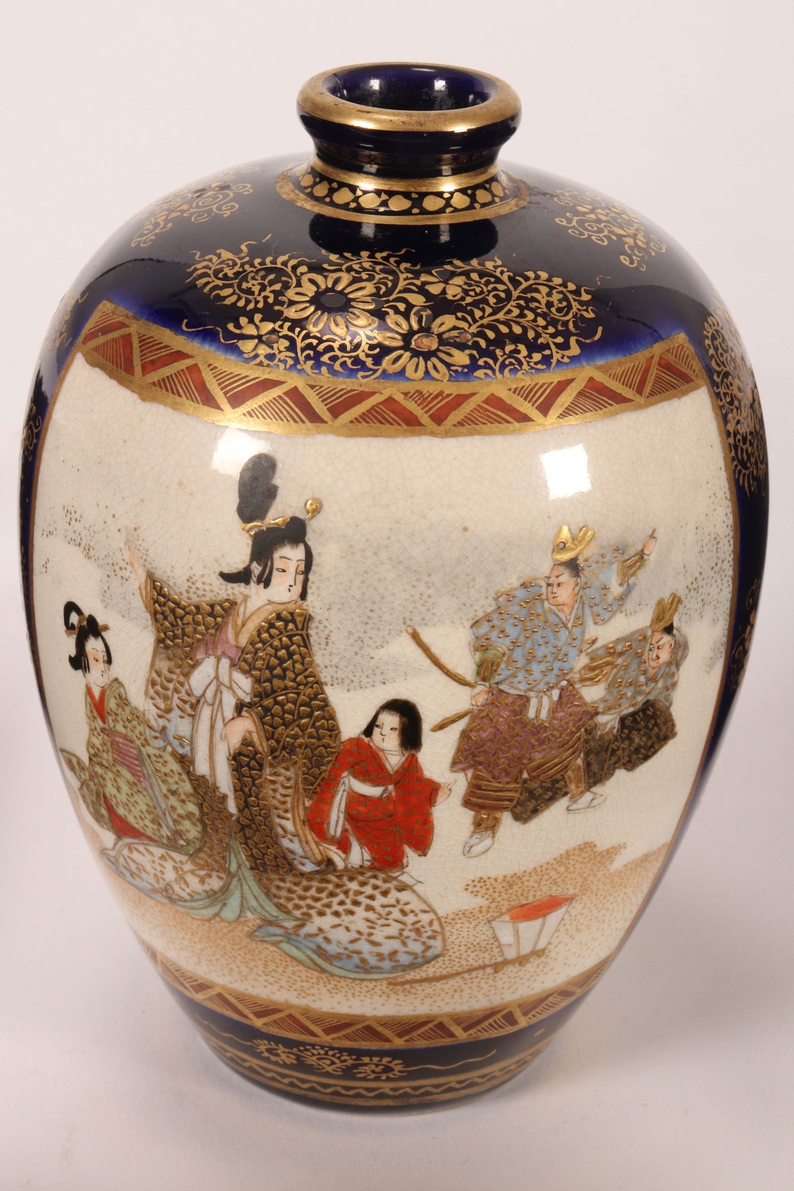 Japanese Satsuma Meiji Period Vase,: of ovoid form with a short neck, decorated with two reserves depicting geishas, attendants and warriors, on a cobalt ground with gilt floral decoration, mark to base, height 12.5cm
