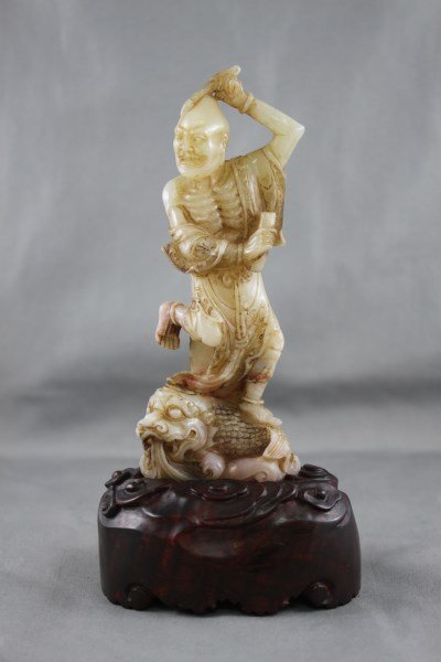 Chinese Carved Soapstone Figure,: depicting an emaciated man standing on a mythical beast, h 17cm (with stand)