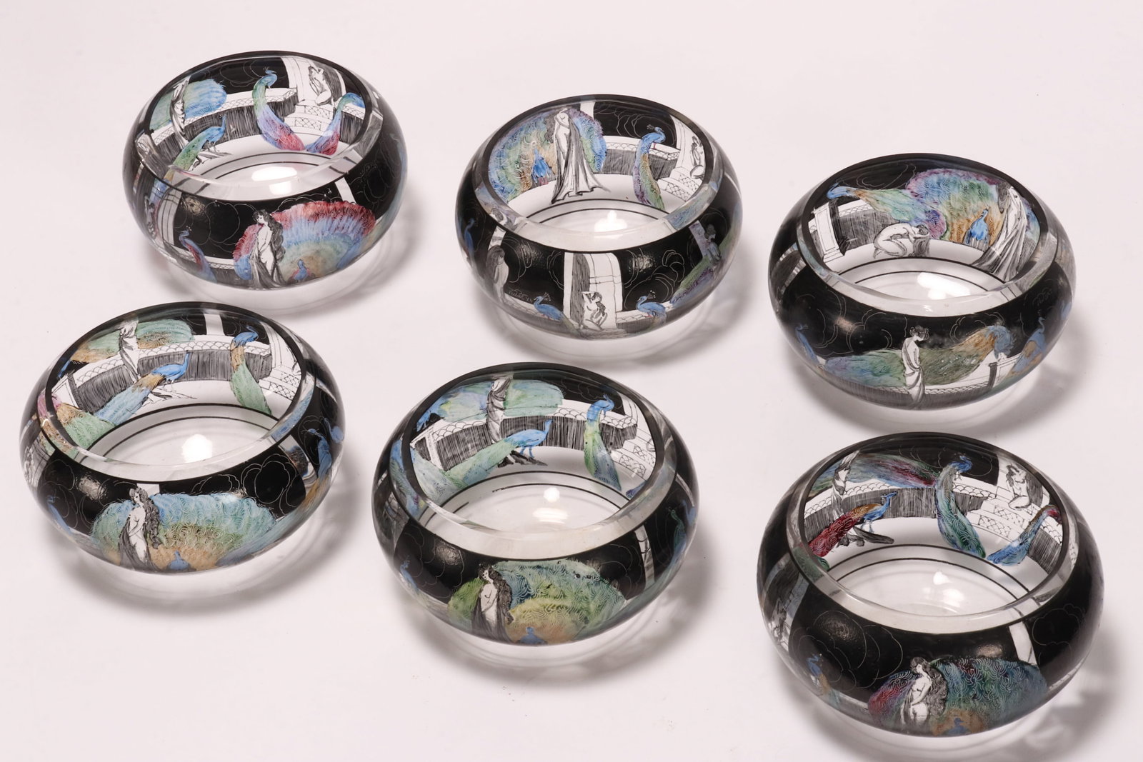 Six Italian Art Deco Glass Finger Bowls,: by Vedar for Vetri d'Arte, decorated with enamelled peacocks and female figures in various scenes, signed Vedar XII, height 7.5cm and diameter 12cm (6)