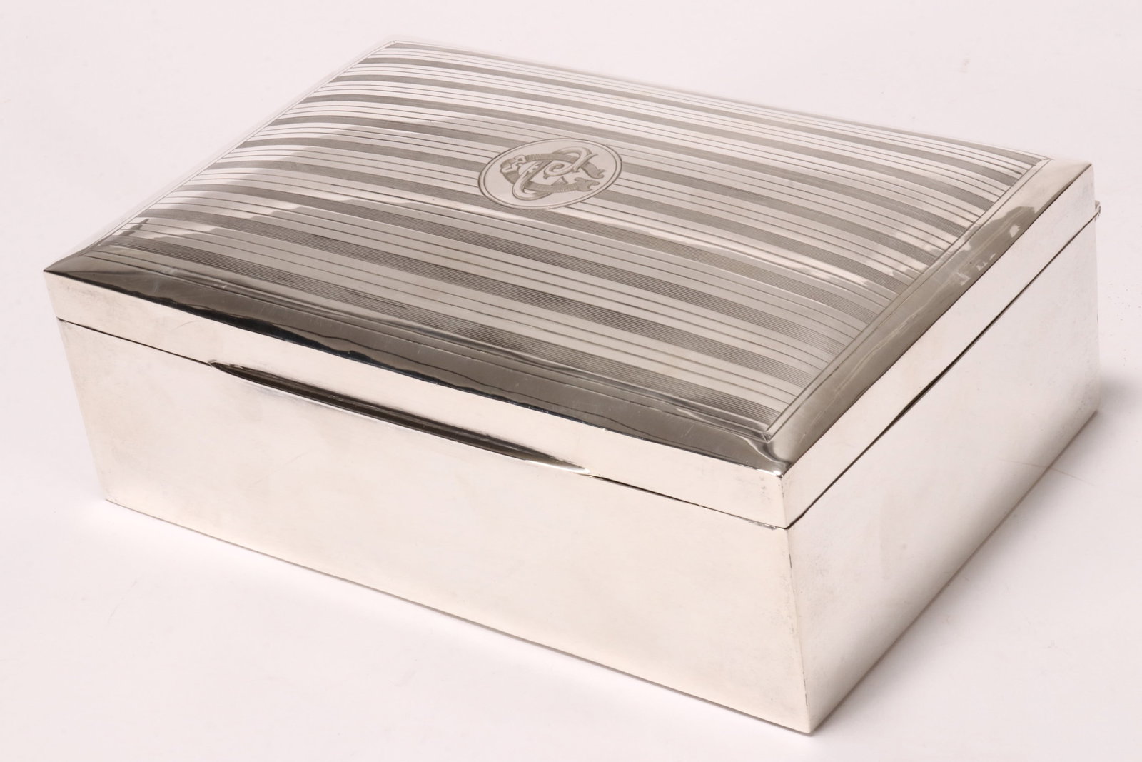 Grand George V Sterling Silver Cigar Box,: hallmarked Chester, 1911, JD//WD (James Deakin & Sons (John & William F Deakin), of rectangular form, the hinged cover engraved with central monogram, surrounded by engine turned banding, opening to r