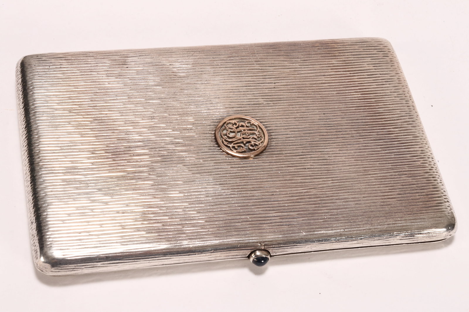 Aspreys of London Sterling Silver Cigarette Case,: hallmarked Chester, 1910, A&C LTD (Asprey London), of rectangular form, with linear textured design to cover and body, the cover set to the center with a circular 14ct pierced gold monogram plaque, op