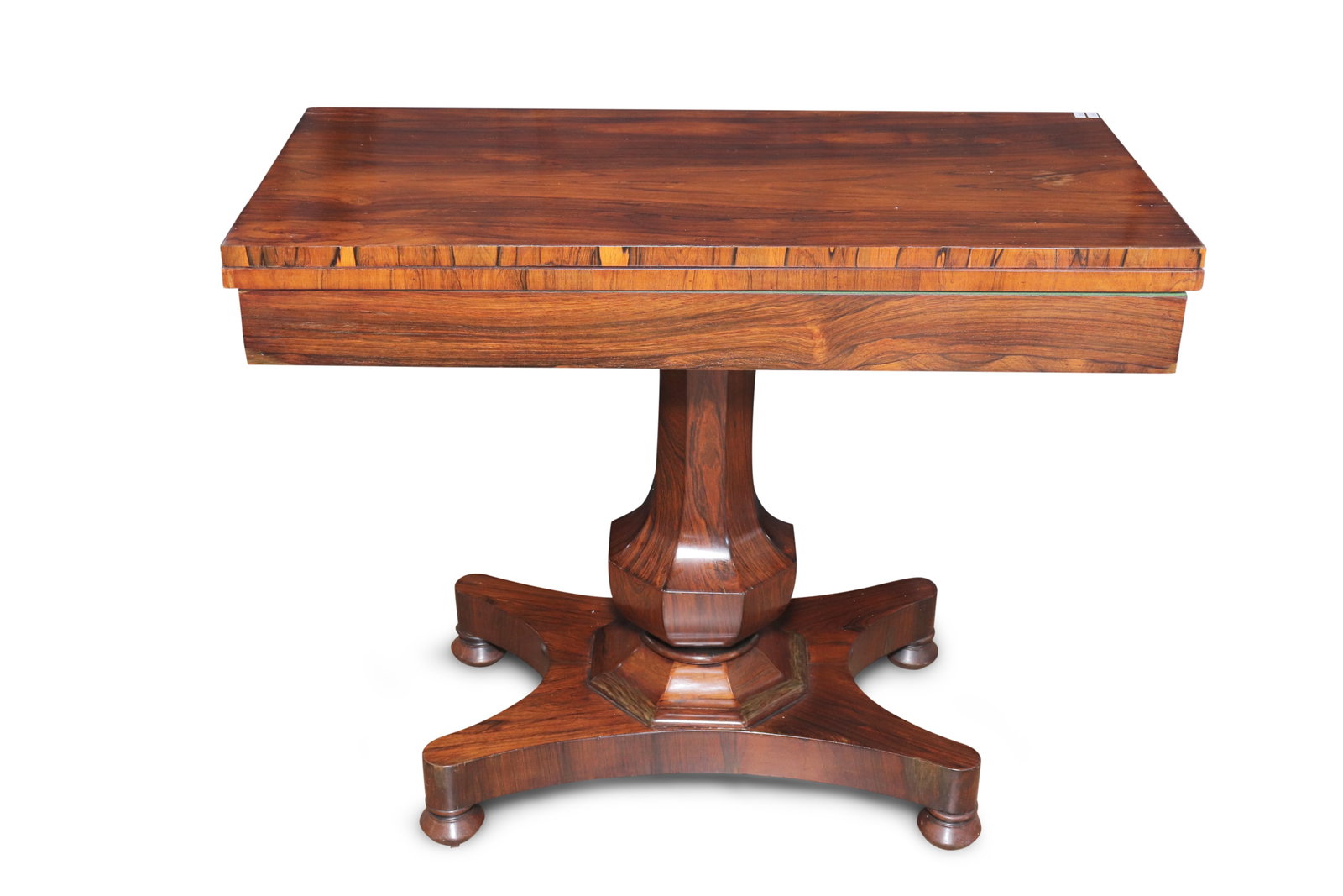 William IV Rosewood Card Table,: the rectangular foldover top with rosewood inlay, set above an octagonal baluster pedestal, on a quatrefoil base, height 76cm x width 94cm x depth 46cm