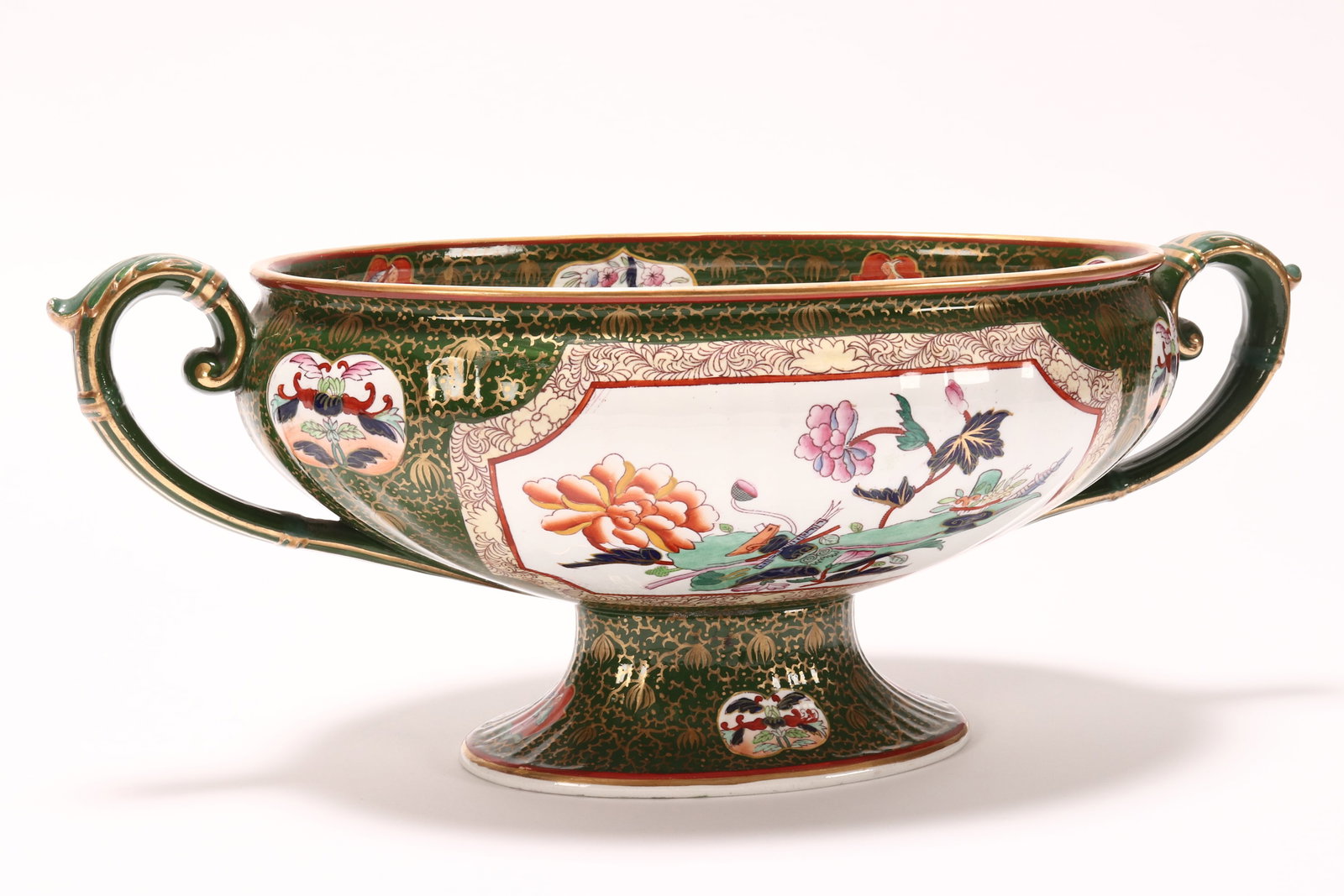 19th Century Ironstone Twin Handled Tureen,: of oval form, in Trophies pattern on a green ground, with heavy gilt accents, marked and impressed Ashworth to base, height 15cm and width 39cm