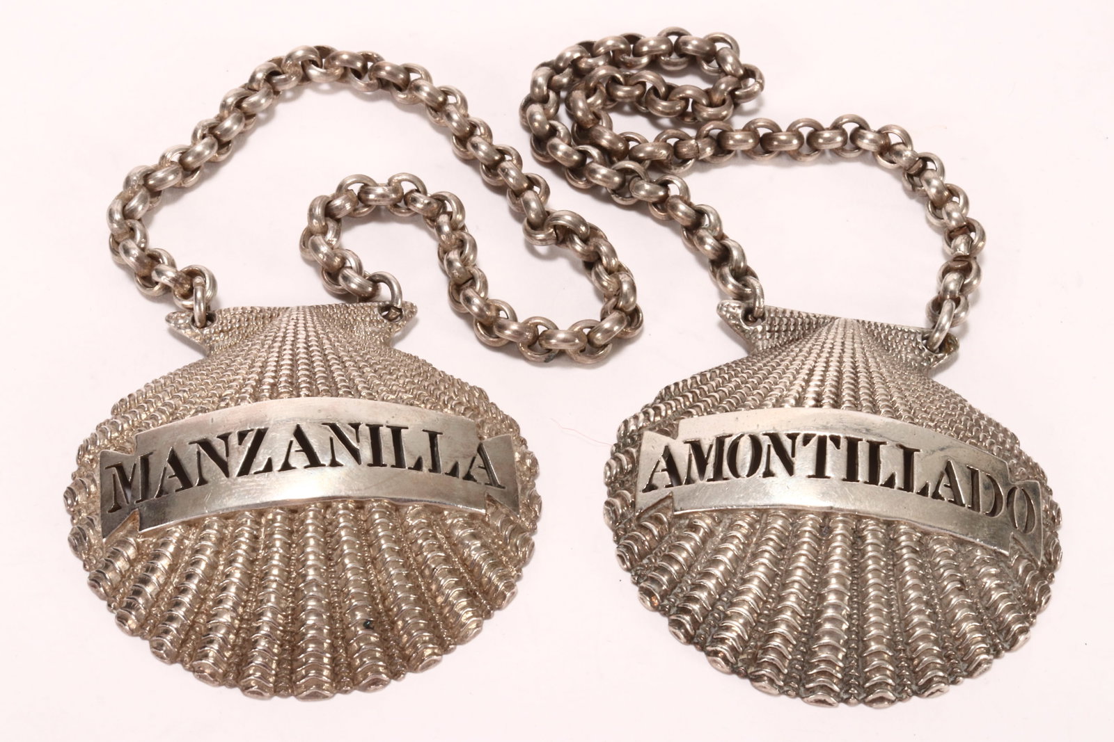 Stunning Pair of Victorian Cast Sterling Silver Decanter Labels,: hallmarked London, 1875, William Summers, of fine shell form, comprising pierced labels for 'Manzanilla' and 'Alontillado,' total weight 85g (including chains), 5cm x 5.3cm