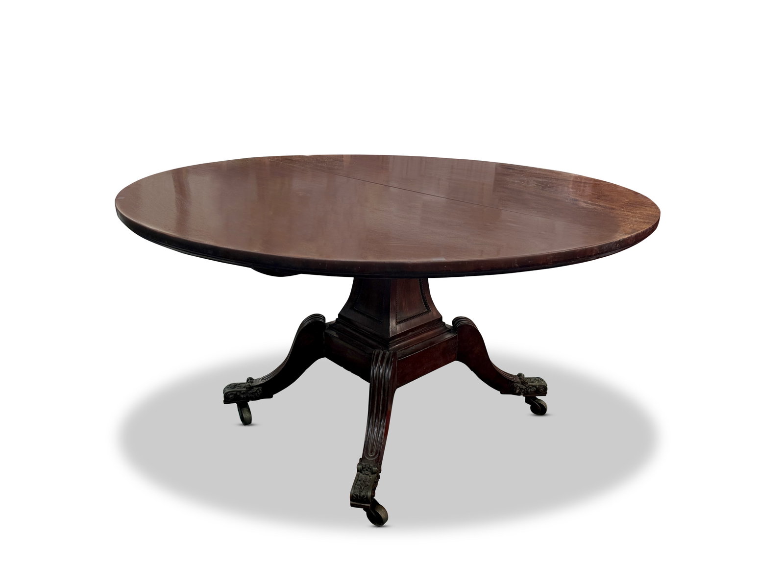 Generous Regency Centre Table,: the circular top on a tapering facetted support with beaded panels, raised on four generous reeded out swept legs, with bronze feet on casters, height 73cm and diameter 137cm Provenance: Purchased Joh