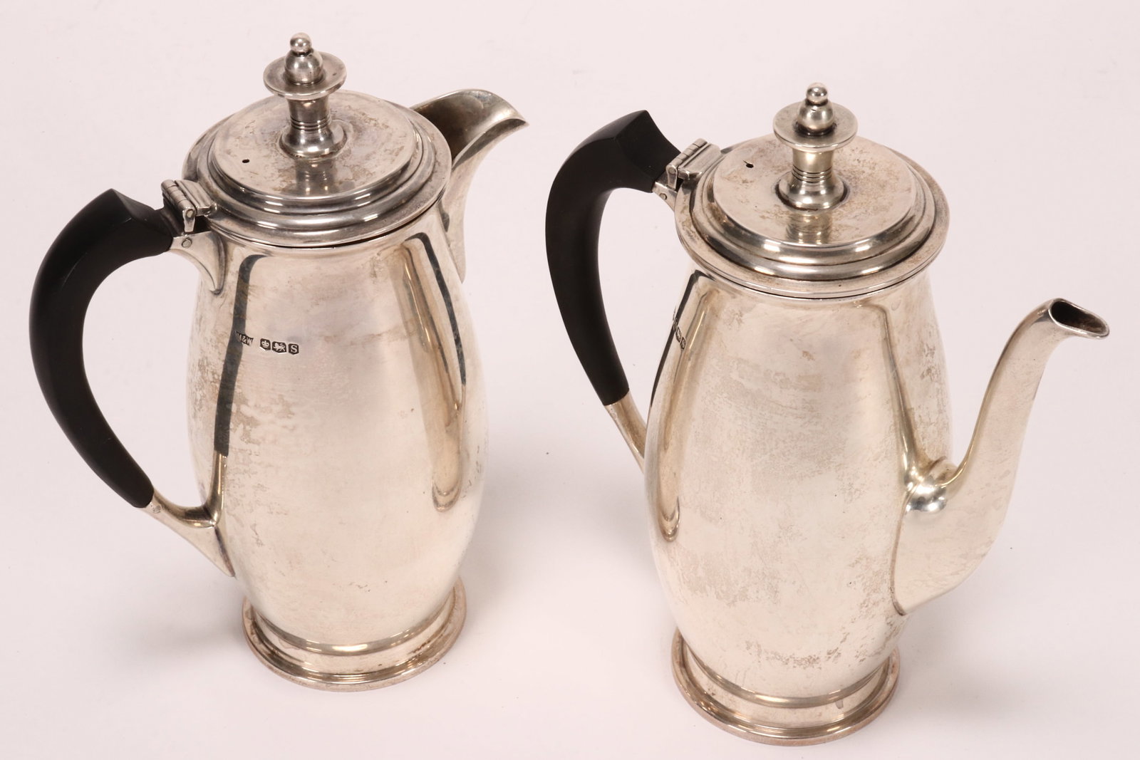 Pair of Elizabeth II Sterling Silver Coffee and Chocolate Pots,: hallmarked Sheffield, 1960, Mappin & Webb, each with a hinged cover set with bud finial, above an elliptical body, raised on a circular foot, with ebonised handle, total weight 847g (including handles