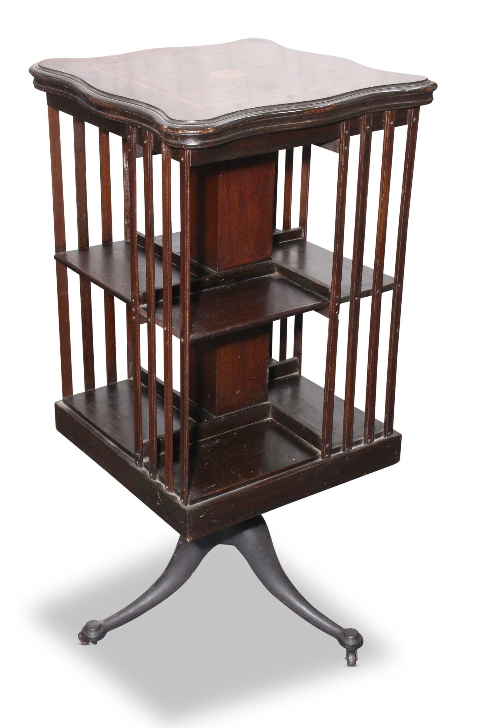 Edwardian Revolving Bookcase,: of rectangular form, set with a square shaped top with central inlaid floral roundel, surrounded by stringing and banded borders, above a series of shelves on a cast metal base, with downward swept fe