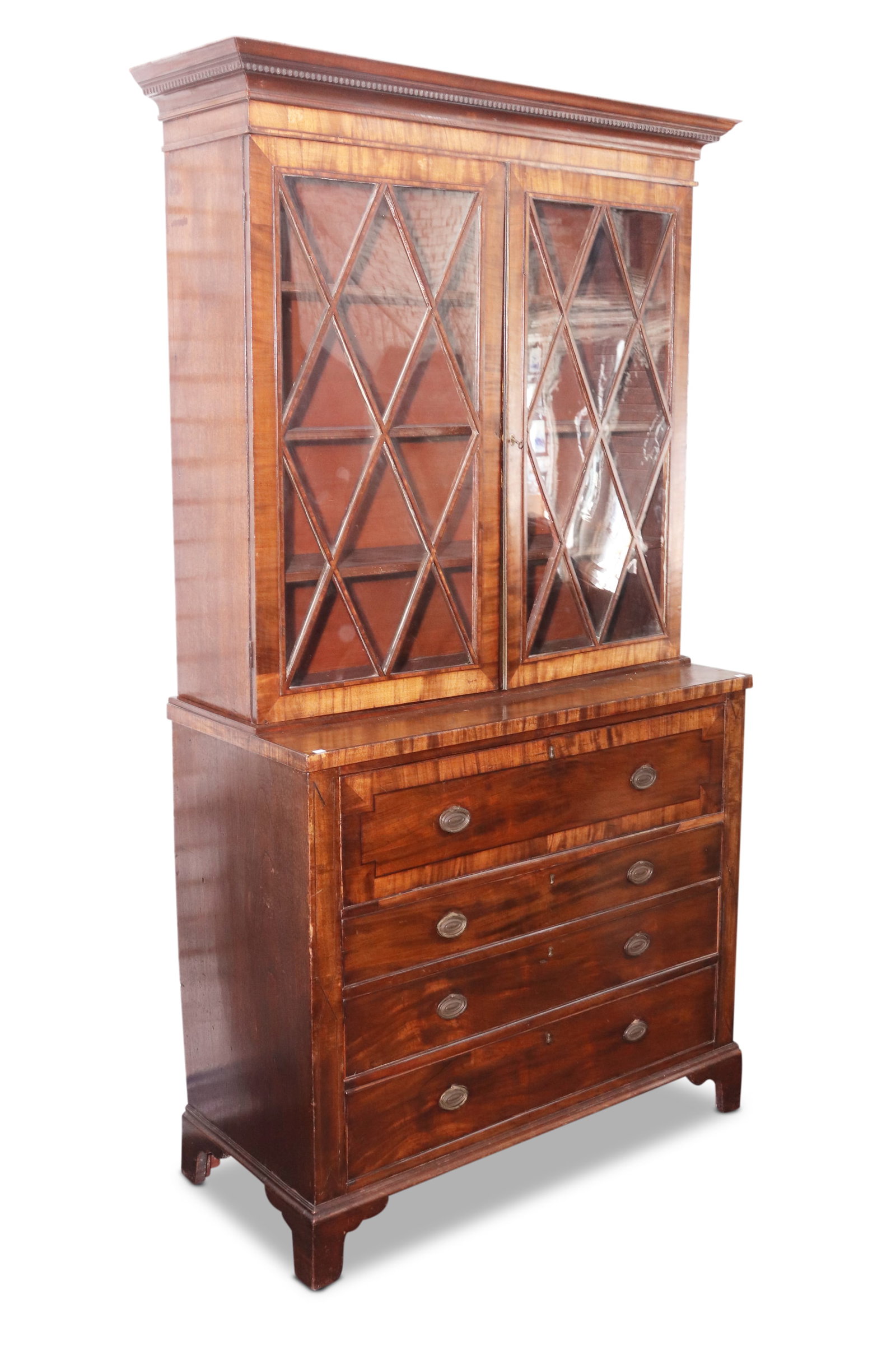 Late Georgian Secretaire Bookcase,: with spreading pediment, above dental molding and a pair of glazed astragal doors, opening to shelves, with a secretaire drawer with fitted interior, above three graduated drawers with cross banded bo