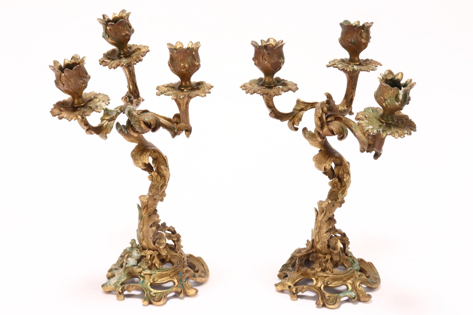 Pair of Gilt Bronze Candelabras,: in the Rococo taste, set with scrolled acanthus branches, each surmounted by a bud sconce, the stem accented with cast blossoms, raised on a pierced foliate base, height 30cm (2)