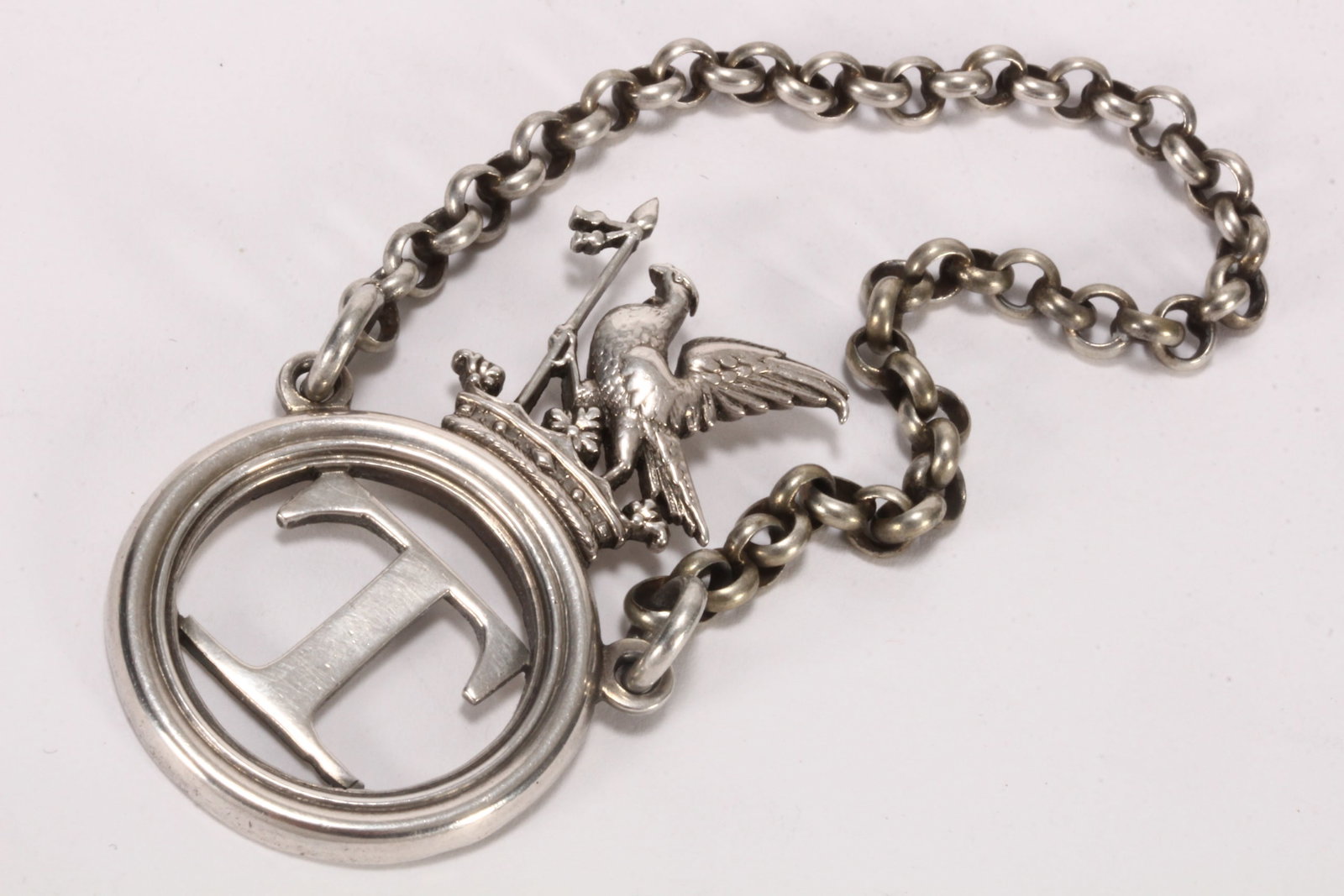 Charles IV Sterling Silver Armorial Decanter Label,: hallmarked London, 1829, Charles Reily & George Storer, decorated with an eagle holding a staff and perched upon a coronet, above a roundel with 'T' for Tinta or Tenerife, with chain, total weight 20g
