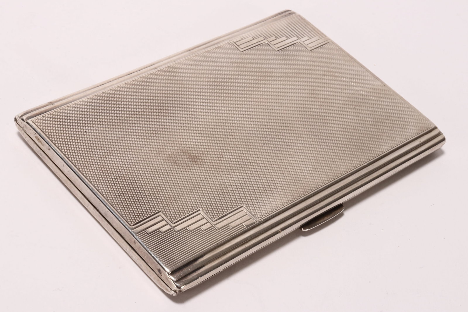 George V Sterling Silver Cigarette Case,: hallmarked Birmingham, 1932, T&S (Turner & Simpson Ltd), of rectangular form, decorated with Art Deco motif on an engine turned ground, the interior in gilt wash with inscription 'Bud from Enid//1933'