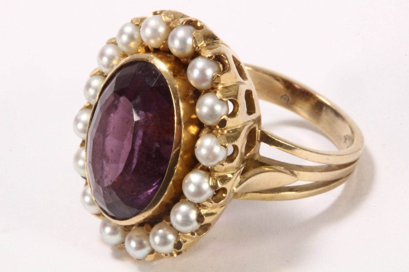 18ct Gold Amethyst & Seed Pearl Cocktail Ring,: stamped 18ct, bezel set with an 8.00ct approx. oval cut amethyst stone, encircled by sixteen claw set seed pearls, on an 18ct gold setting and band, total weight 14.5g, size P