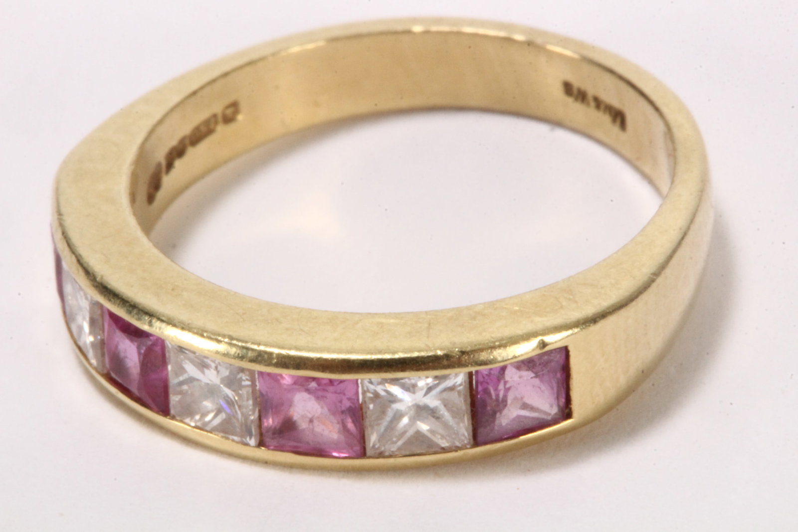 Elizabeth II 18ct Gold Diamond and Ruby Ring,: stamped 750, London, 1995, Mn & Wb (Mappin & Webb), with attractive seven stone channel setting, comprising three princess cut diamonds of approx. 0.50ct total, divided by four princess cut rubies tot