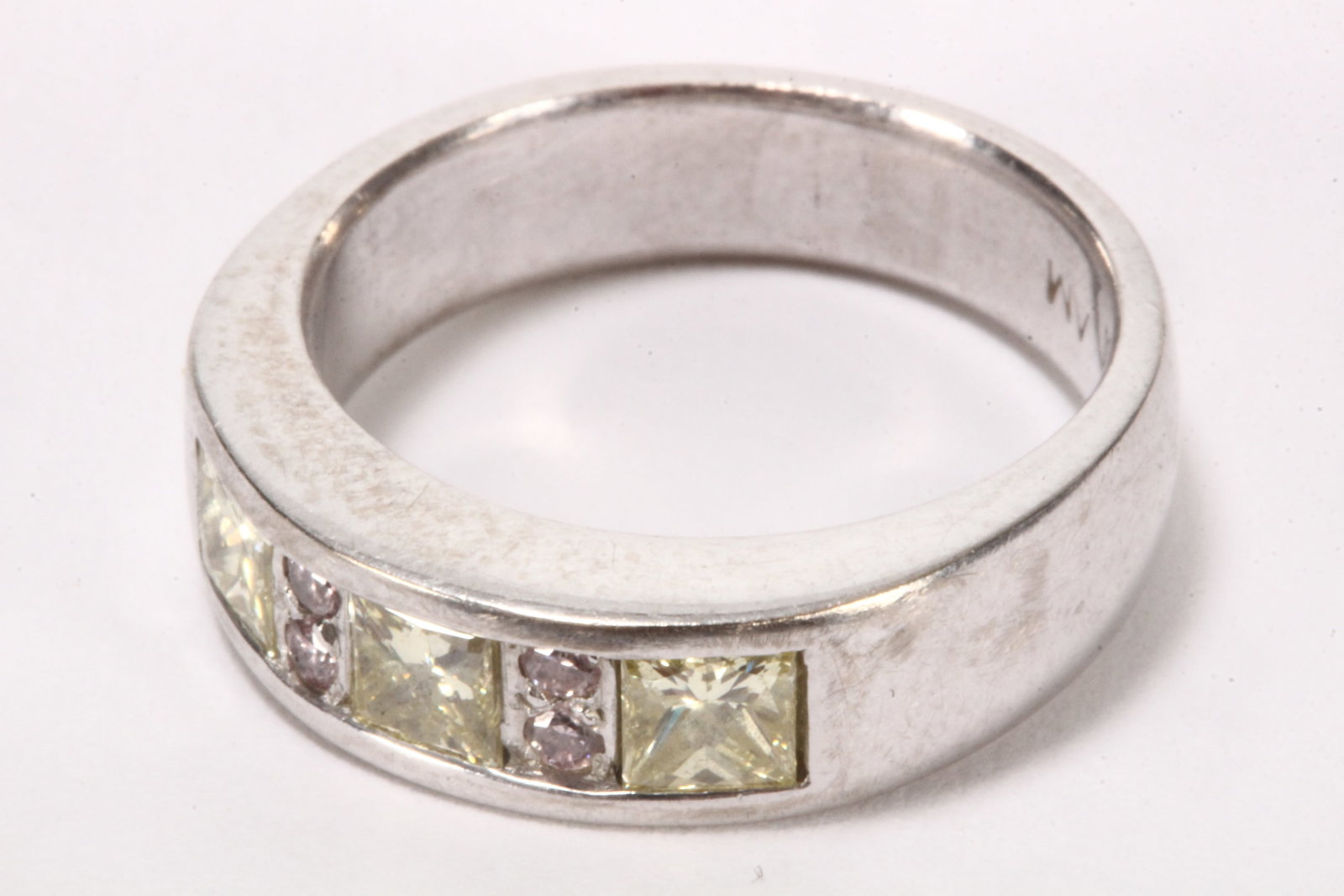 18ct White Gold Pink and Yellow Diamond Ring,: stampd 750, AM, the channel setting with three princess cut yellow diamonds of approx. 0.75ct total, divided by two banks of two small round cut pink diamonds, total weight 7.3g, size J/K