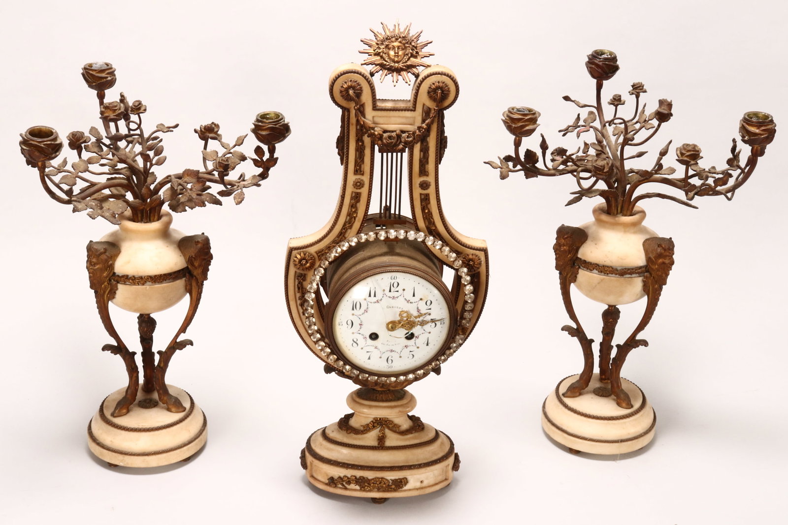 Good 19th Century French Clock Garniture,: by E.Gleizes of Paris, in marble and gilt brass, the clock of lyre form, with gilt brass bead trim framing inset fruiting vine panels, rosettes and swags, surmounted by sunburst medallion, the frame s