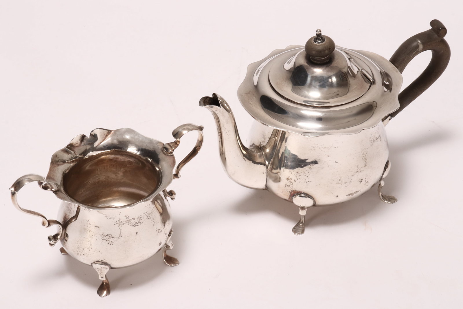Edwardian Sterling Silver Bachelor's Teapot and Twin Handled Sugar Bowl,: hallmarked Chester, 1907, Walker & Hall, with serpentine rim, above a plain bulbous body, total weight 404g (including wooden handle and finial), height of teapot 13cm (2)