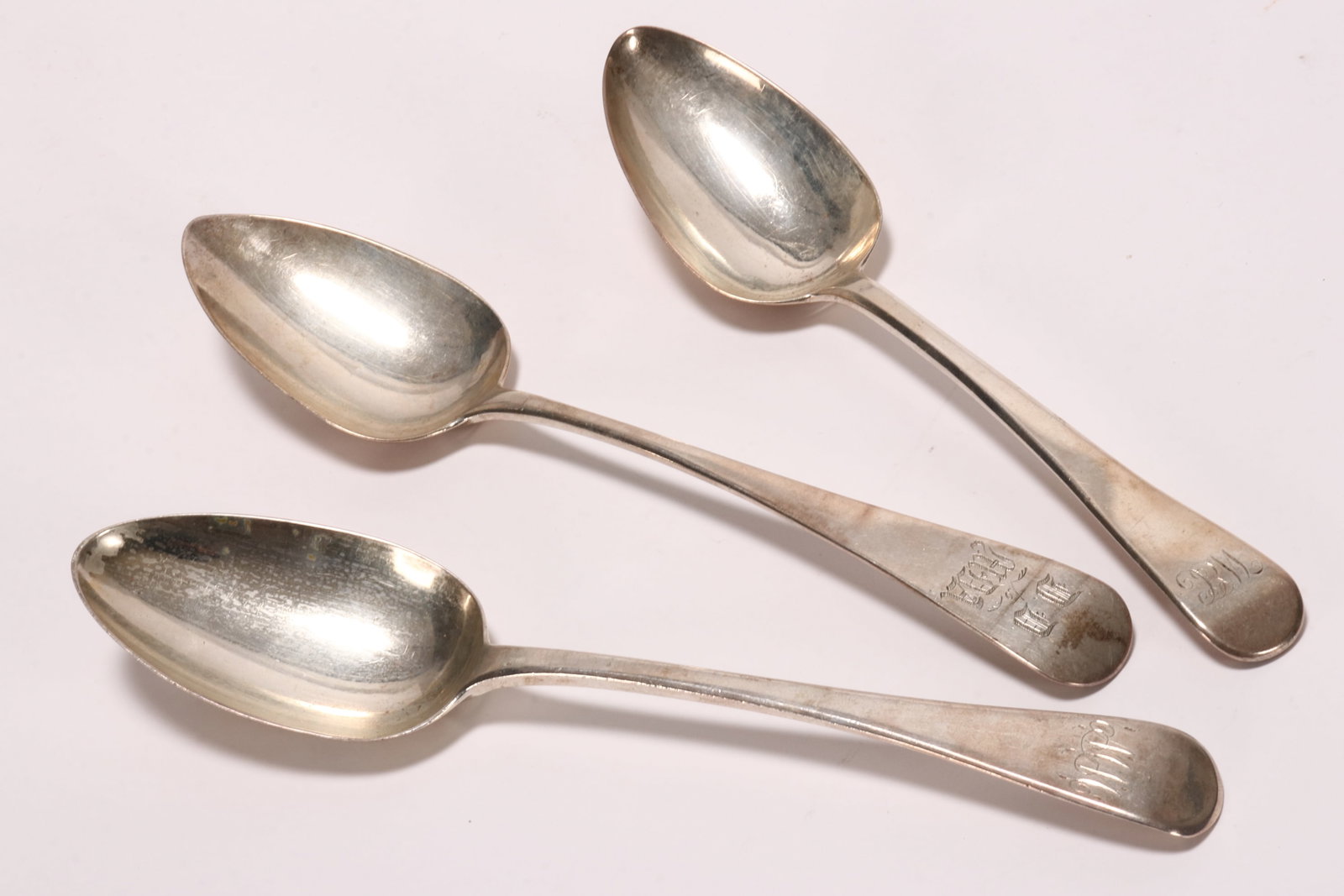 Three George III Sterling Silver Table Spoons,: hallmarked London, 1817, WE//WF (William Eley I & William Fearn), London, 1806, SH (Solomon Hougham), the other hallmarked Exeter, 1818, JH (Joseph Hicks), in Old English pattern, with engraved monogr