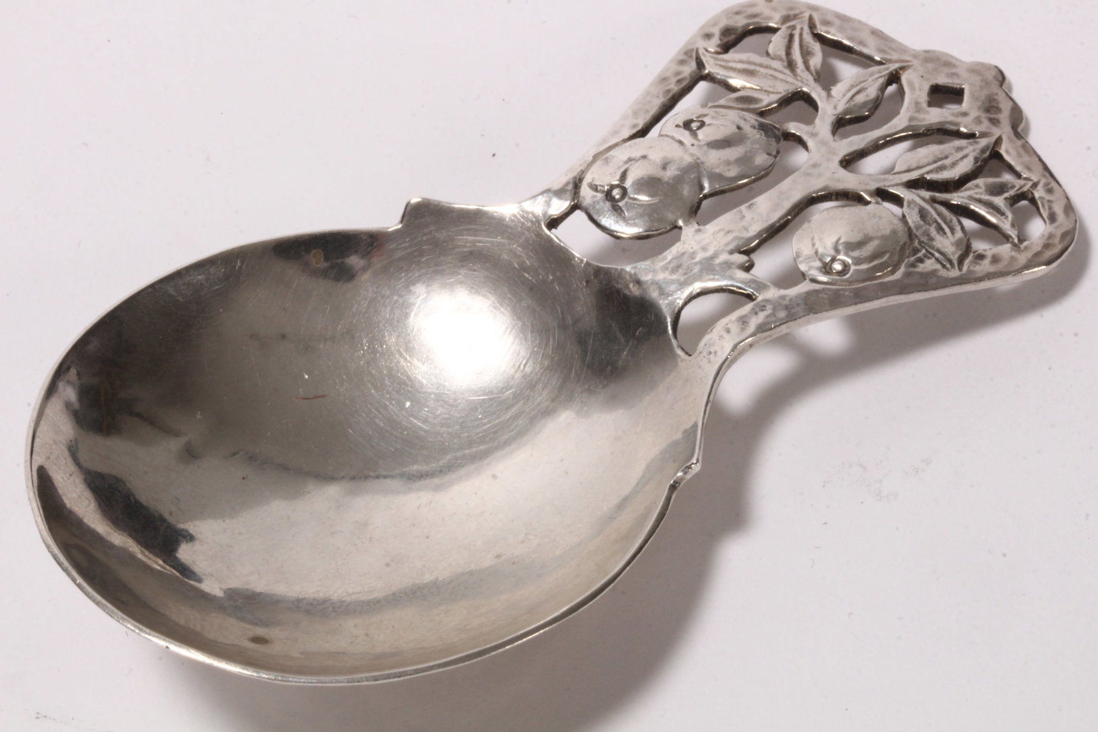 Arts and Crafts Sterling Silver Caddy Spoon,: hallmarked Birmingham, 1928, Bernard Instone, the handle in the form of a pierced apple tree, above a generous bowl, total weight 27g, length 8.2cm