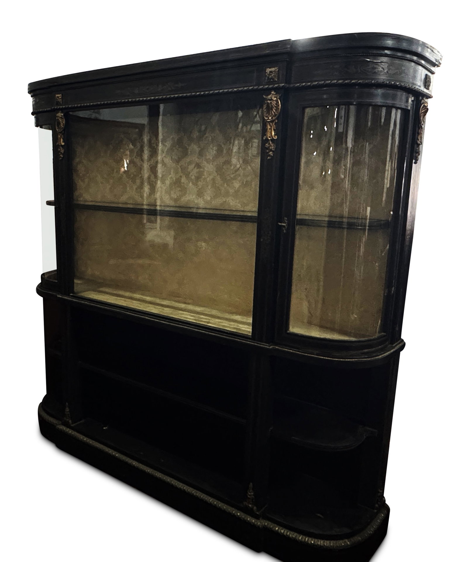 19th Century French Ebonised Display Cabinet,: of demi lune form, the glass fronted top set with large central glass panel, flanked by curved glass doors, opening to a cream silk brocade lined interior with single glass shelf, raised above two ope