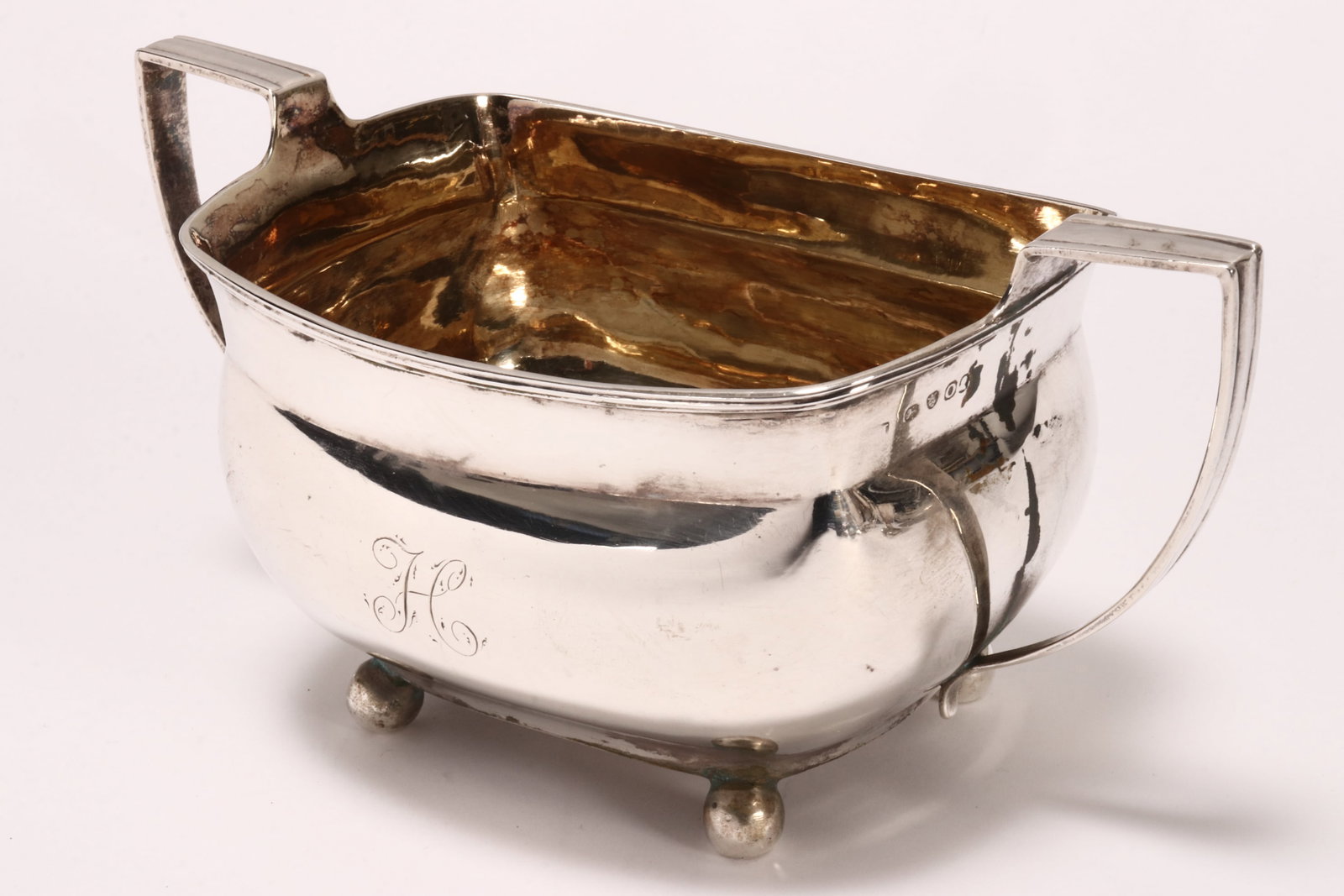 Large George III Sterling Silver Sugar Bowl,: hallmarked London, 1809, makers mark rubbed, of plain bulbous form, with twin angled handles and engraved 'H' to front, raised on three ball feet, with gilt interior, total weight 253g, height 9.5cm a