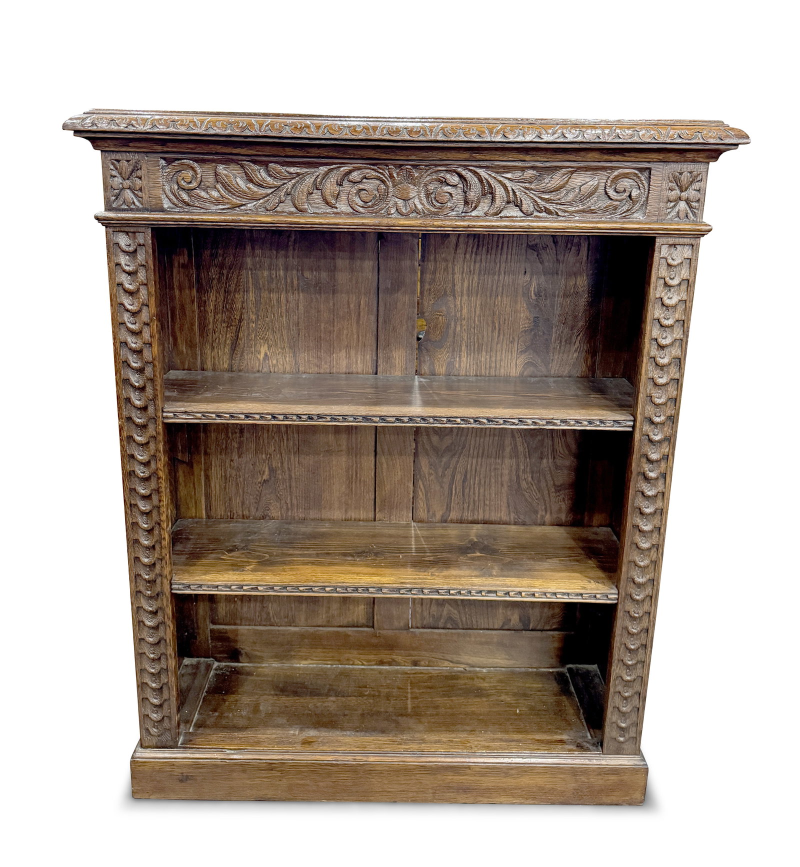 Edwardian Oak Open Bookcase,: the rectangular top with a carved frieze displaying scrolls and leaves, above two fitted shelves, on a plinth base, 112cm x 91.5cm x 29cm