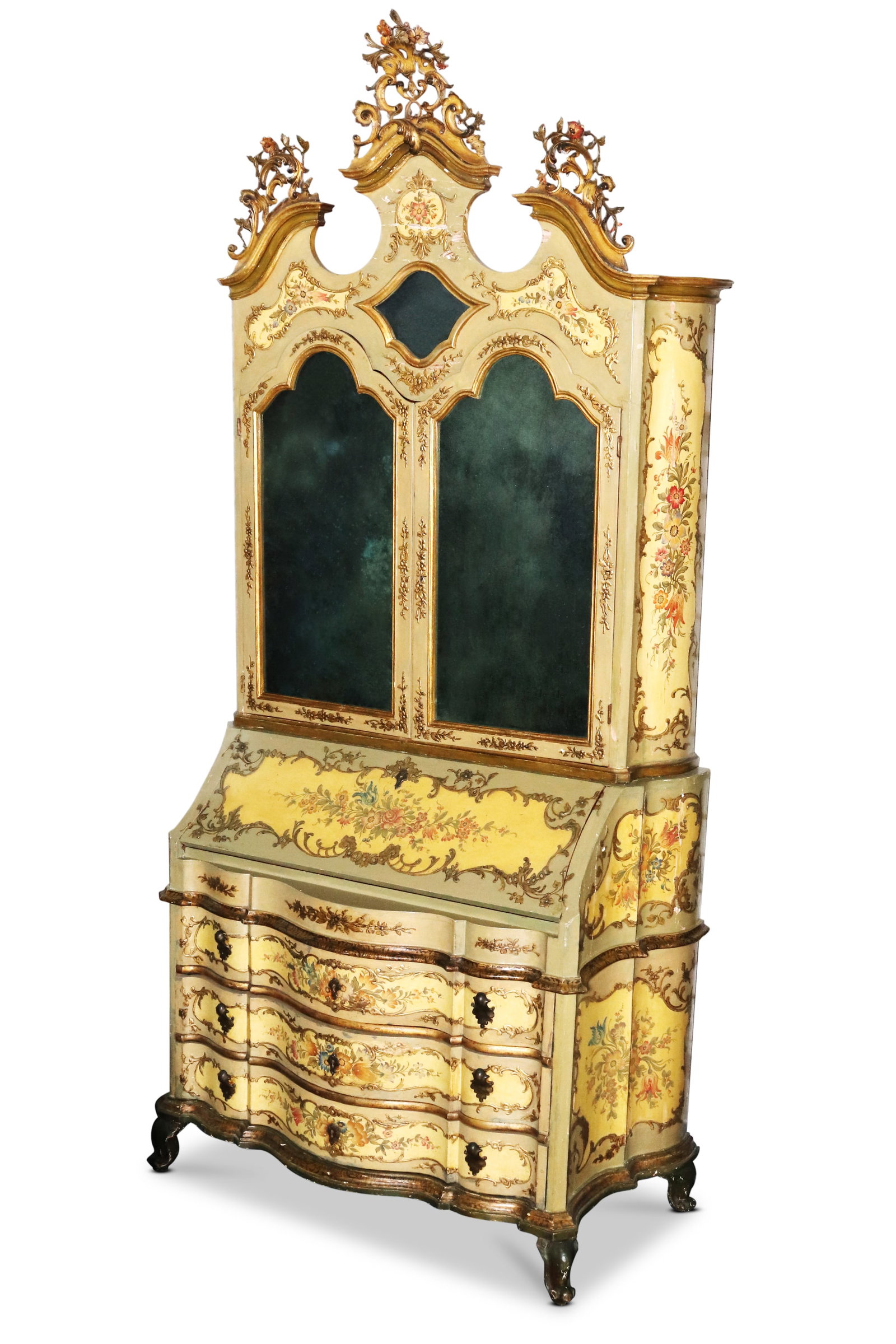Venetian Lacca Povera Trumeau Cabinet,: with carved crest rail displaying scroll and foliate motifs, above a pair of shaped mirrored doors, opening to a fitted red lacquer interior, above a fall front and three drawers, decorated with flora