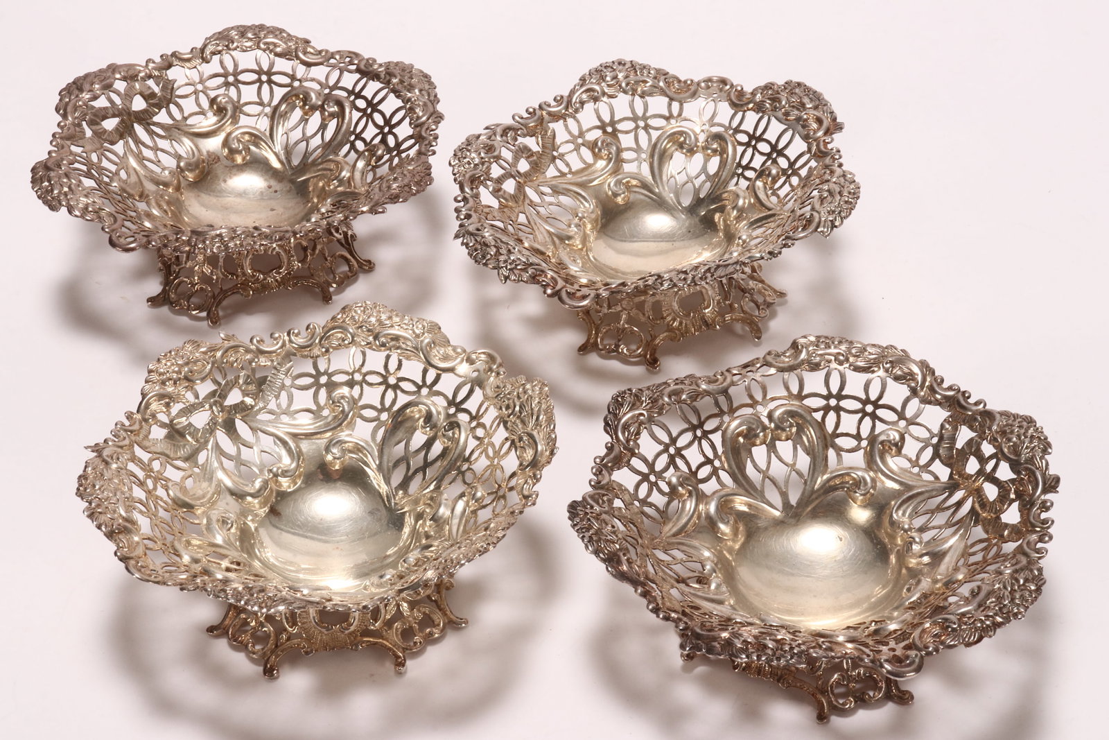 Four Victorian Sterling Silver Bon Bon Dishes,: hallmarked London, 1892, W.C (William Comyns & Sons), pierced and embossed with acanthus and floral motifs, raised on a pierced footed base, total weight 367g, height 4cm and diameter 12cm (4)