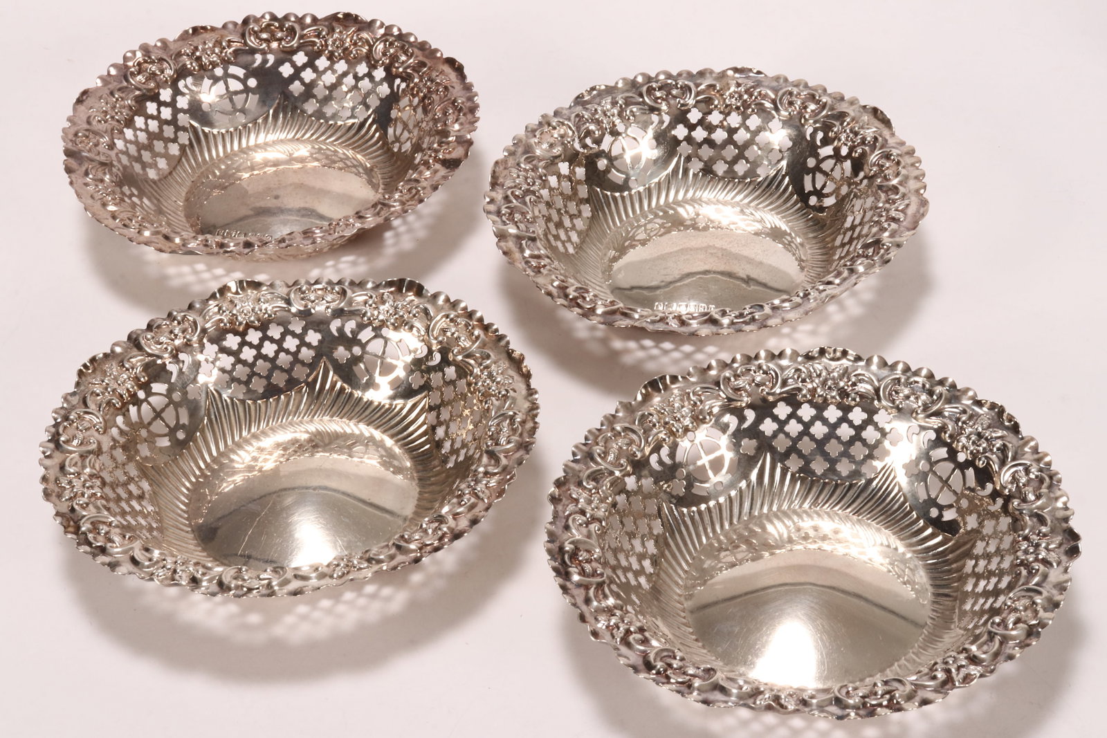 Four Late Victorian/Edwardian Sterling Silver Dishes,: two hallmarked Birmingham, 1897, Deykin & Harrison, the other two hallmarked Sheffield, 1906, John Henry Potter, embossed with floral and acanthus border above pierced sides, total weight 152g, height