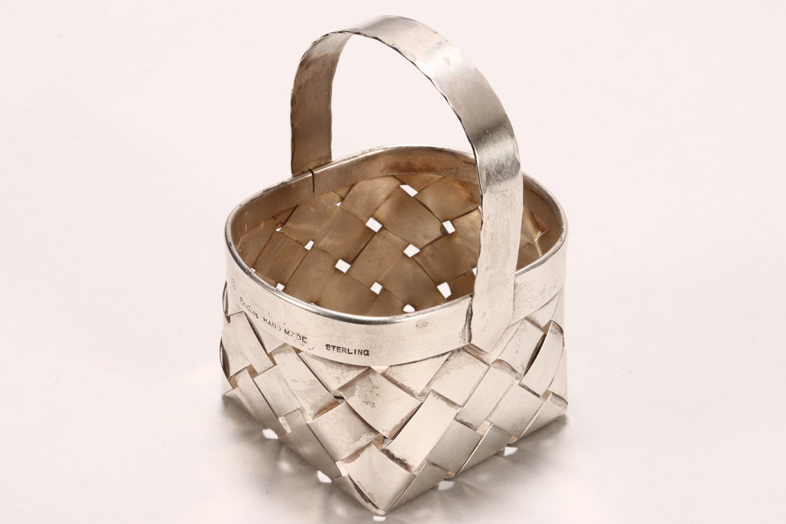Cartier Sterling Silver Basket,: hallmarked Cartier, sterling, with simple loop handle, above body of woven rectangular form, total weight 47g, height 8.5cm and length 6.3cm